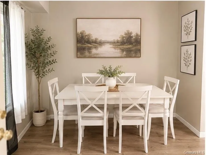 Dining area with wood-finish flooring and neutral wall tones Dining area with wood-finish flooring and neutral wall tones