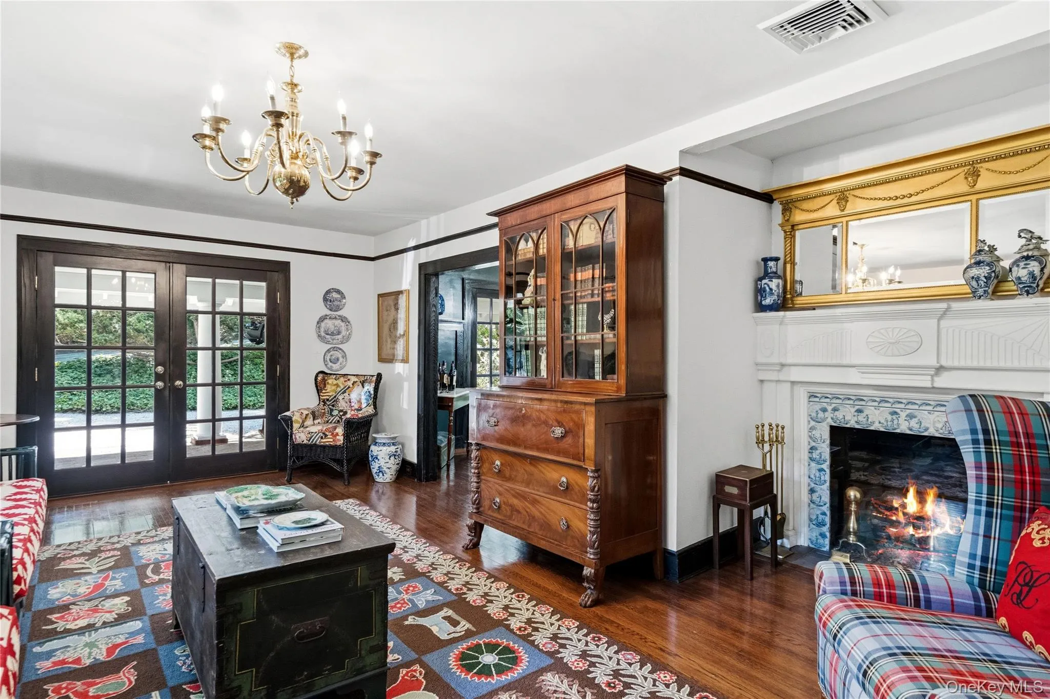 Welcoming living room with french doors open to front porch with wood burning fireplace Welcoming living room with french doors open to front porch with wood burning fireplace