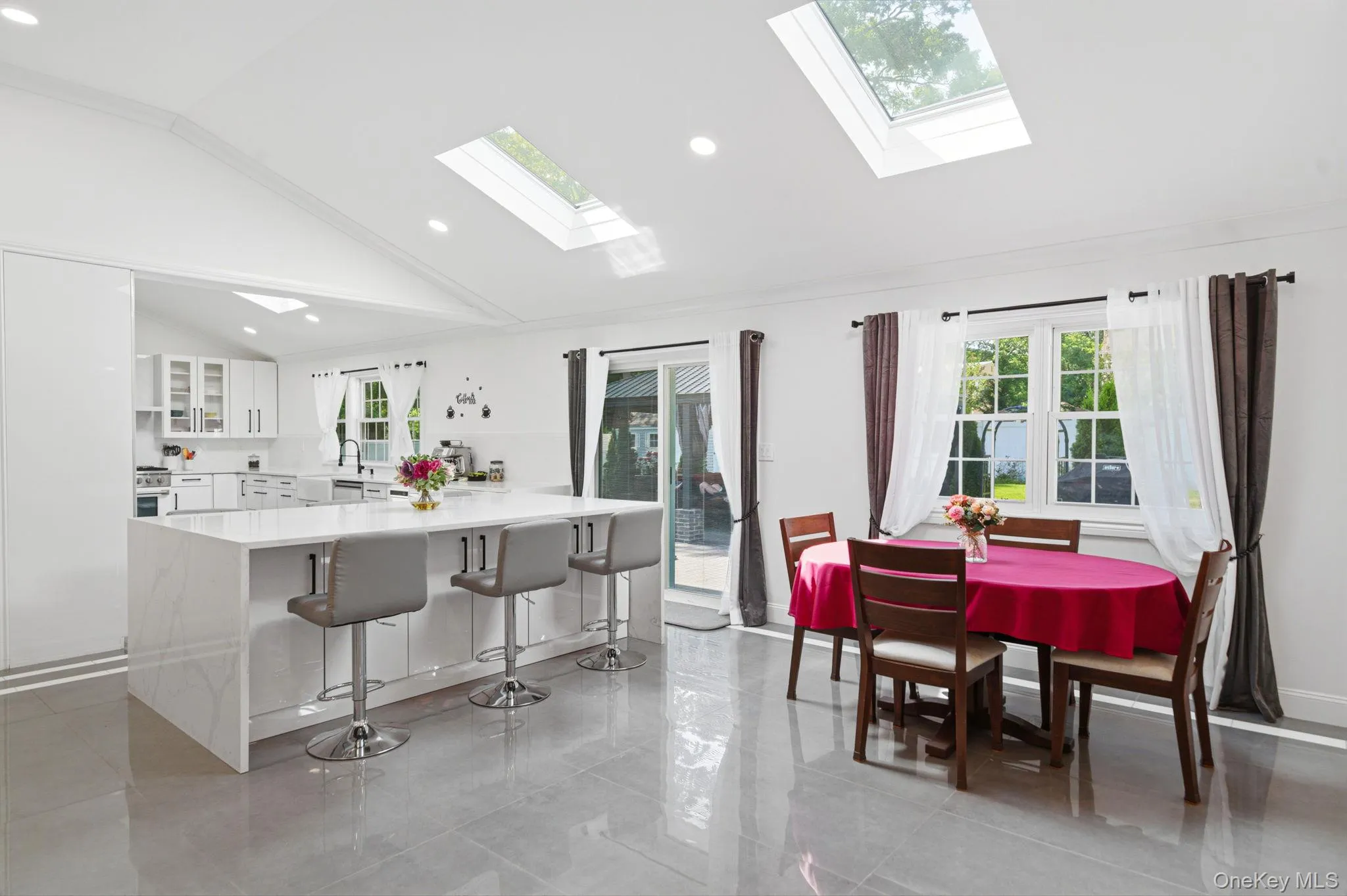 Open and bright floor plan. Dining area with skylights, recessed lighting, porcelain tile, center island with 6-8 seats and cabinets. wall of windows overlooking the backyard. Open and bright floor plan. Dining area with skylights, recessed lighting, porcelain tile, center island with 6-8 seats and cabinets. wall of windows overlooking the backyard.