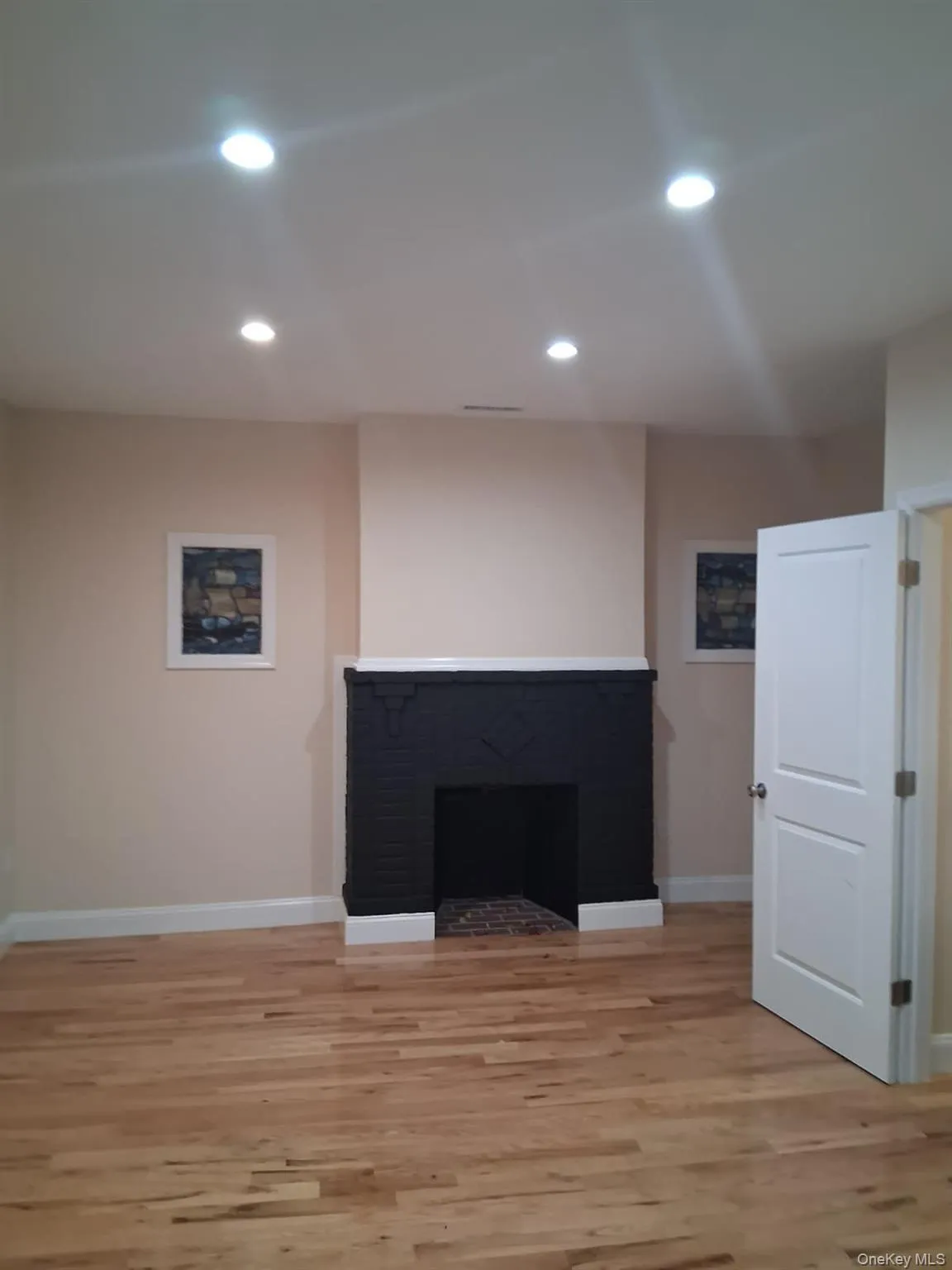 Unfurnished living room with recessed lighting, light wood-style floors, and a fireplace Unfurnished living room with recessed lighting, light wood-style floors, and a fireplace