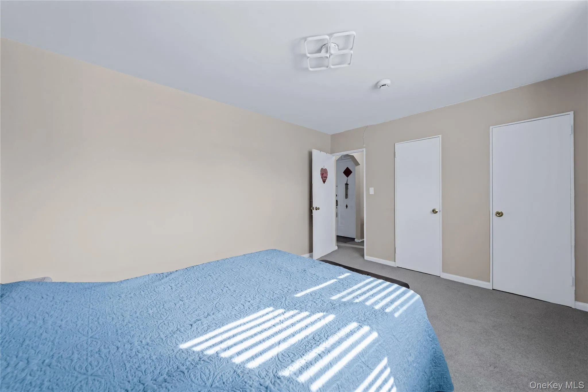 Unfurnished bedroom with carpet floors and two closets Unfurnished bedroom with carpet floors and two closets