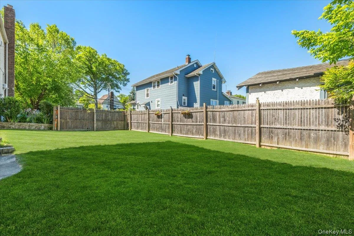 Expansive lawn area featuring a full privacy fence Expansive lawn area featuring a full privacy fence
