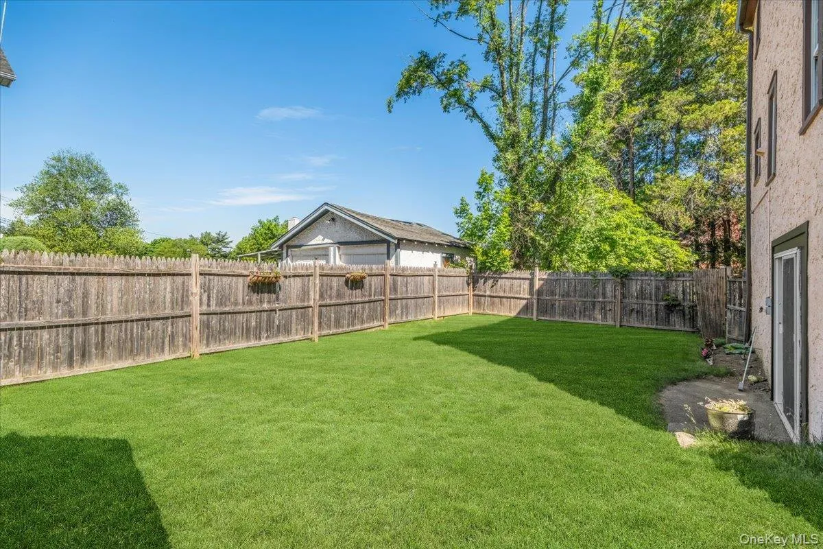 Expansive flat and usable grassy yard featuring a wood privacy fence, and mature trees. Expansive flat and usable grassy yard featuring a wood privacy fence, and mature trees.