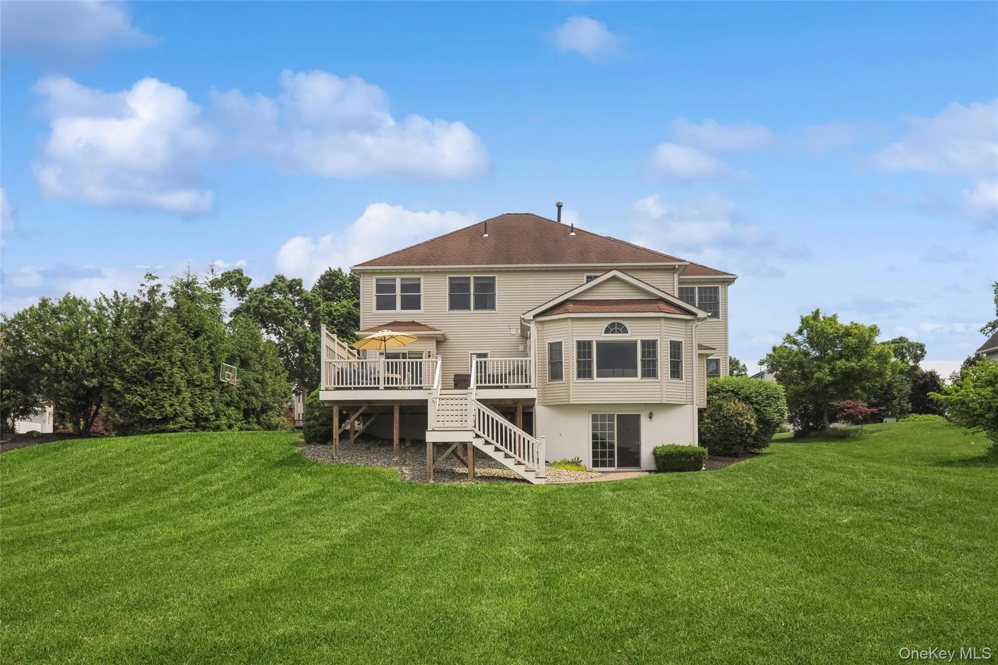Well kept lawn looking to the back of the house and large deck. Well kept lawn looking to the back of the house and large deck.