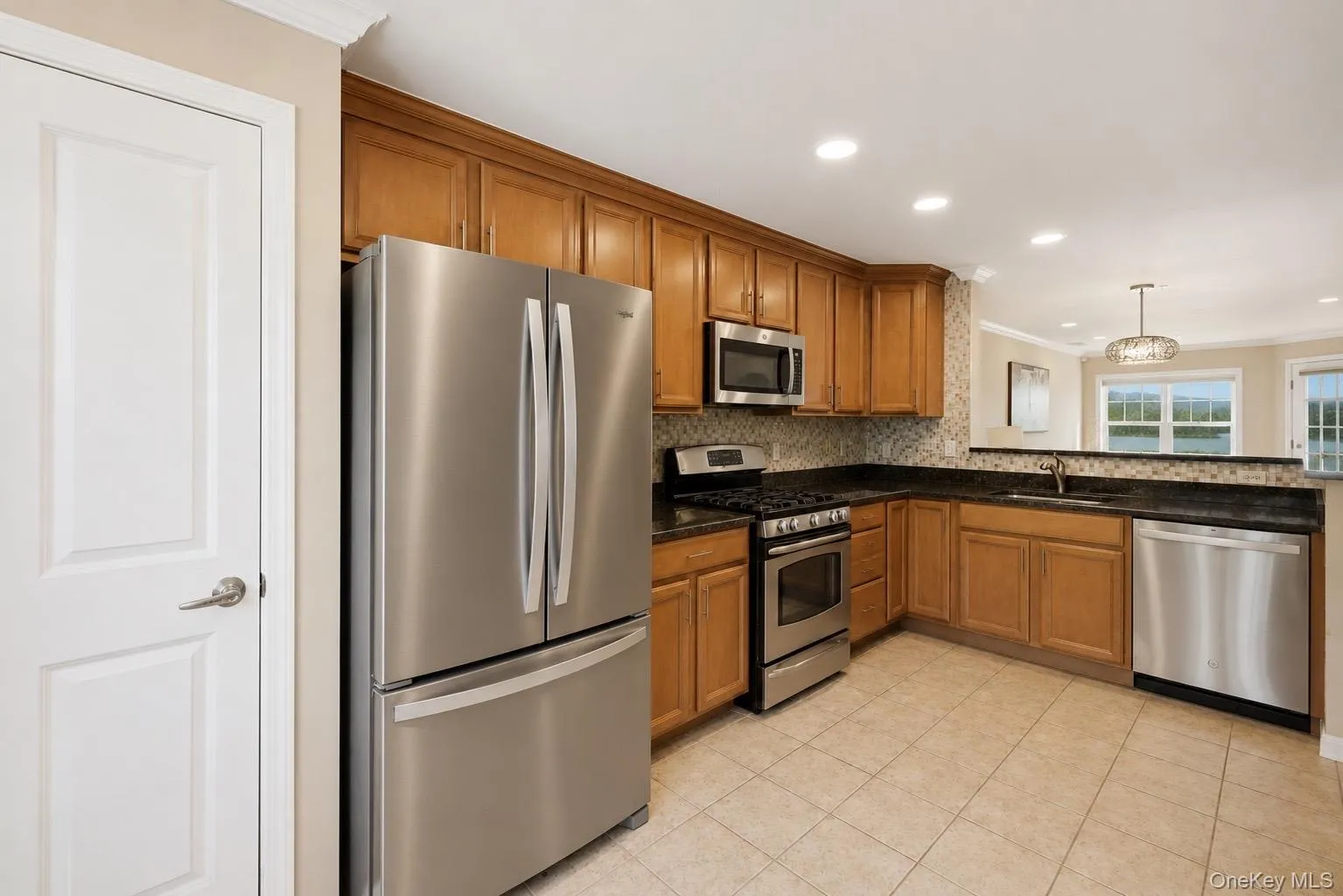 Kitchen featuring new recessed lights, wood cabinetry, stainless steel appliances, granite countertops, and a new mosaic tile backsplash Kitchen featuring new recessed lights, wood cabinetry, stainless steel appliances, granite countertops, and a new mosaic tile backsplash