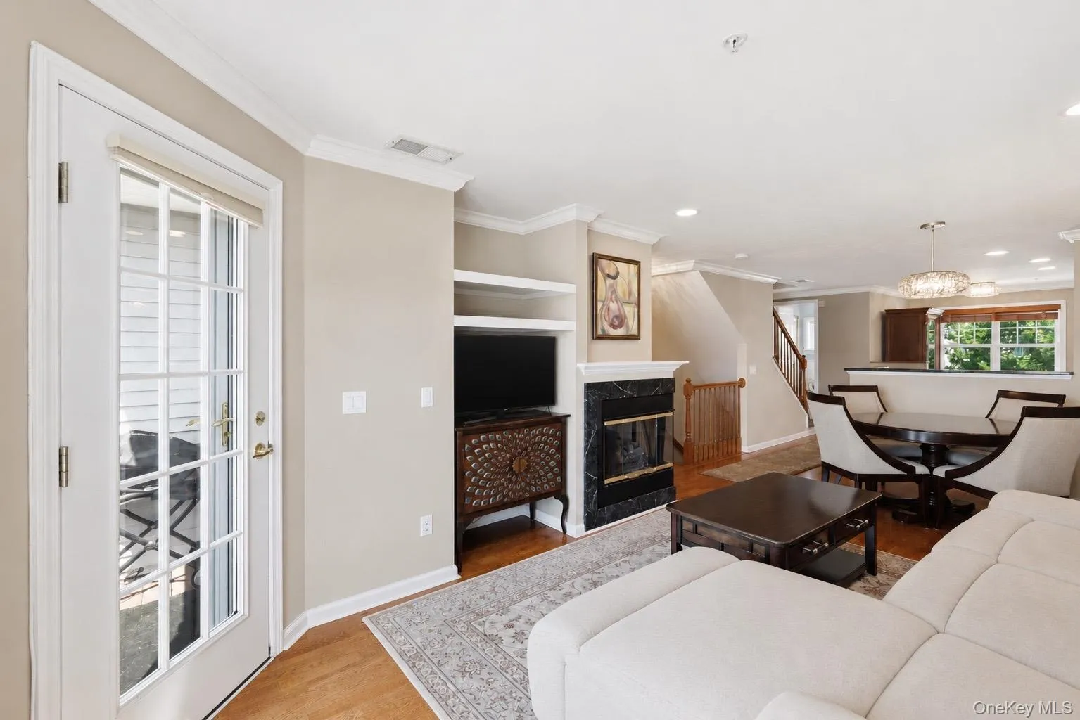 Living area featuring wood flooring, a gas fireplace, and new built-in shelving Living area featuring wood flooring, a gas fireplace, and new built-in shelving