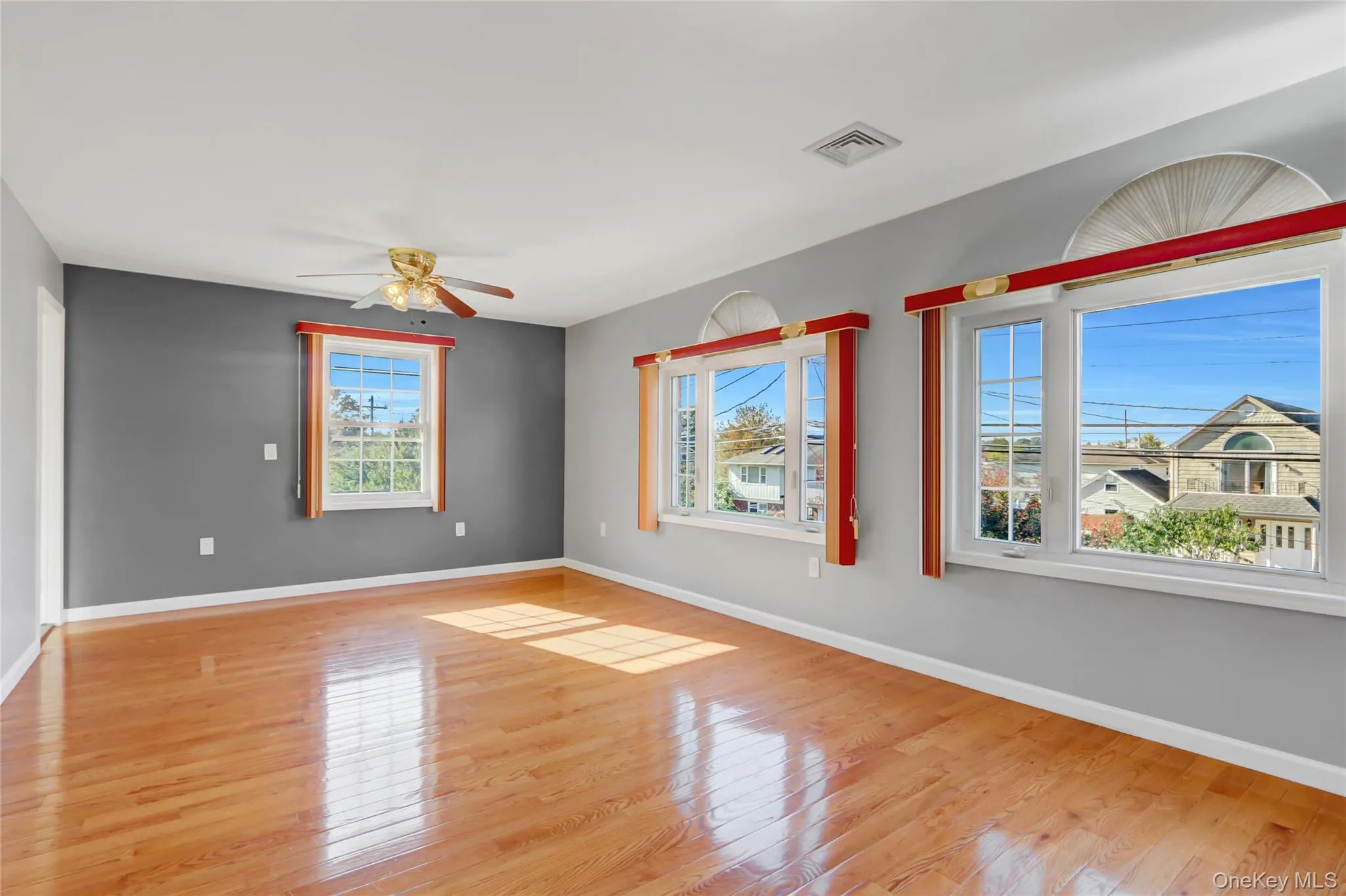 Primary room with Spacious interior with lustrous wood-finish flooring, light gray walls, and recessed lighting Primary room with Spacious interior with lustrous wood-finish flooring, light gray walls, and recessed lighting
