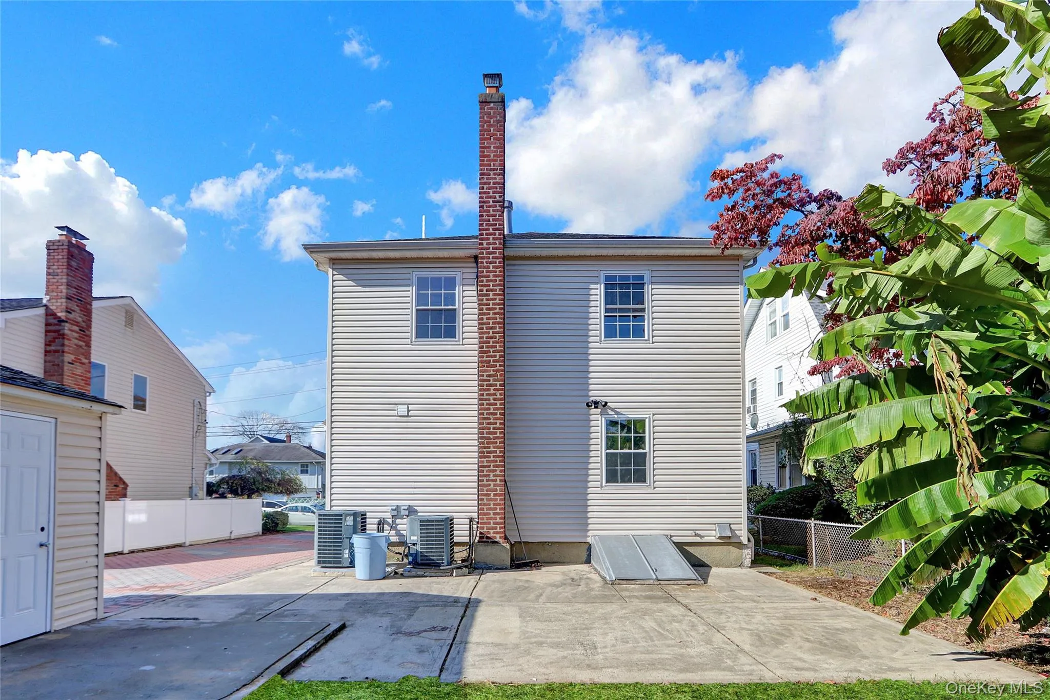Rear exterior with a prominent brick chimney, and multiple double-hung windows Rear exterior with a prominent brick chimney, and multiple double-hung windows