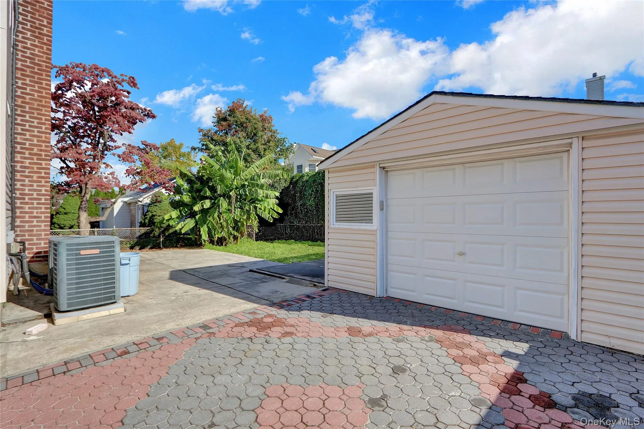 Detached garage with horizontal siding, a white panel garage door and window Detached garage with horizontal siding, a white panel garage door and window