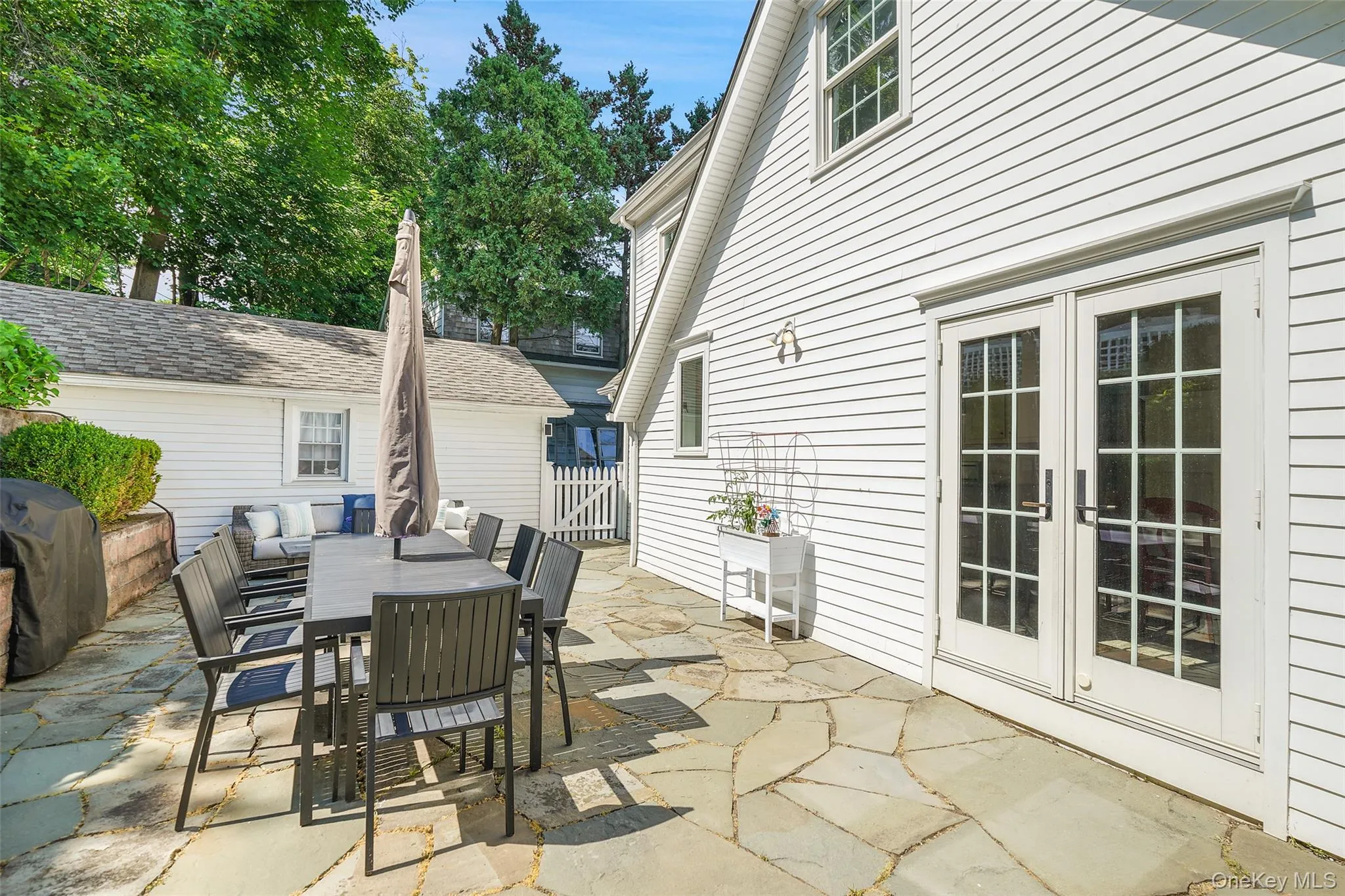 Patio with french doors to kitchen and access to driveway and garage. Patio with french doors to kitchen and access to driveway and garage.