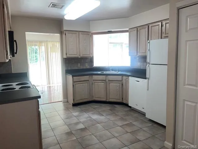 Eat in Kitchen with tile flooring, light wood-finish cabinetry, and dark countertops Eat in Kitchen with tile flooring, light wood-finish cabinetry, and dark countertops