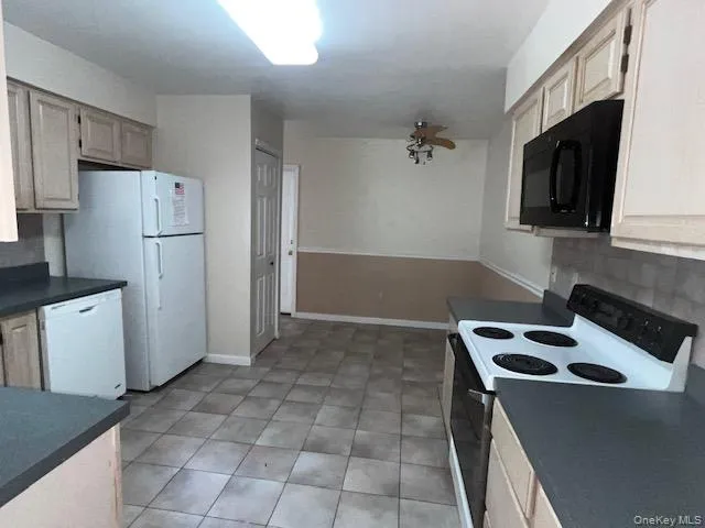 Eat in Kitchen with tile flooring, light wood-finish cabinetry, and dark countertops Eat in Kitchen with tile flooring, light wood-finish cabinetry, and dark countertops