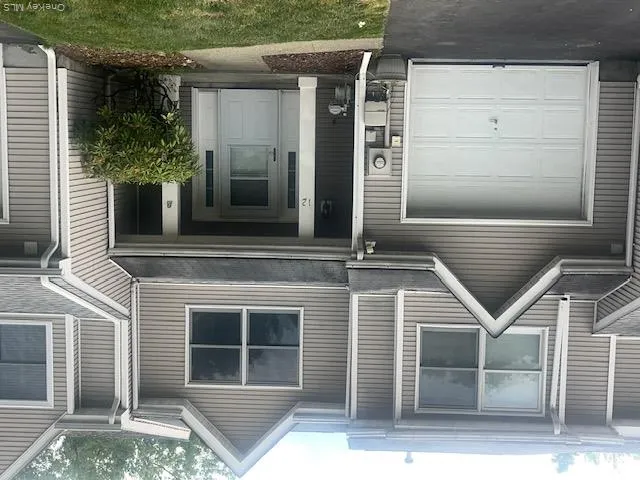 2 story Townhome exterior featuring vinyl siding in a neutral tone 2 story Townhome exterior featuring vinyl siding in a neutral tone
