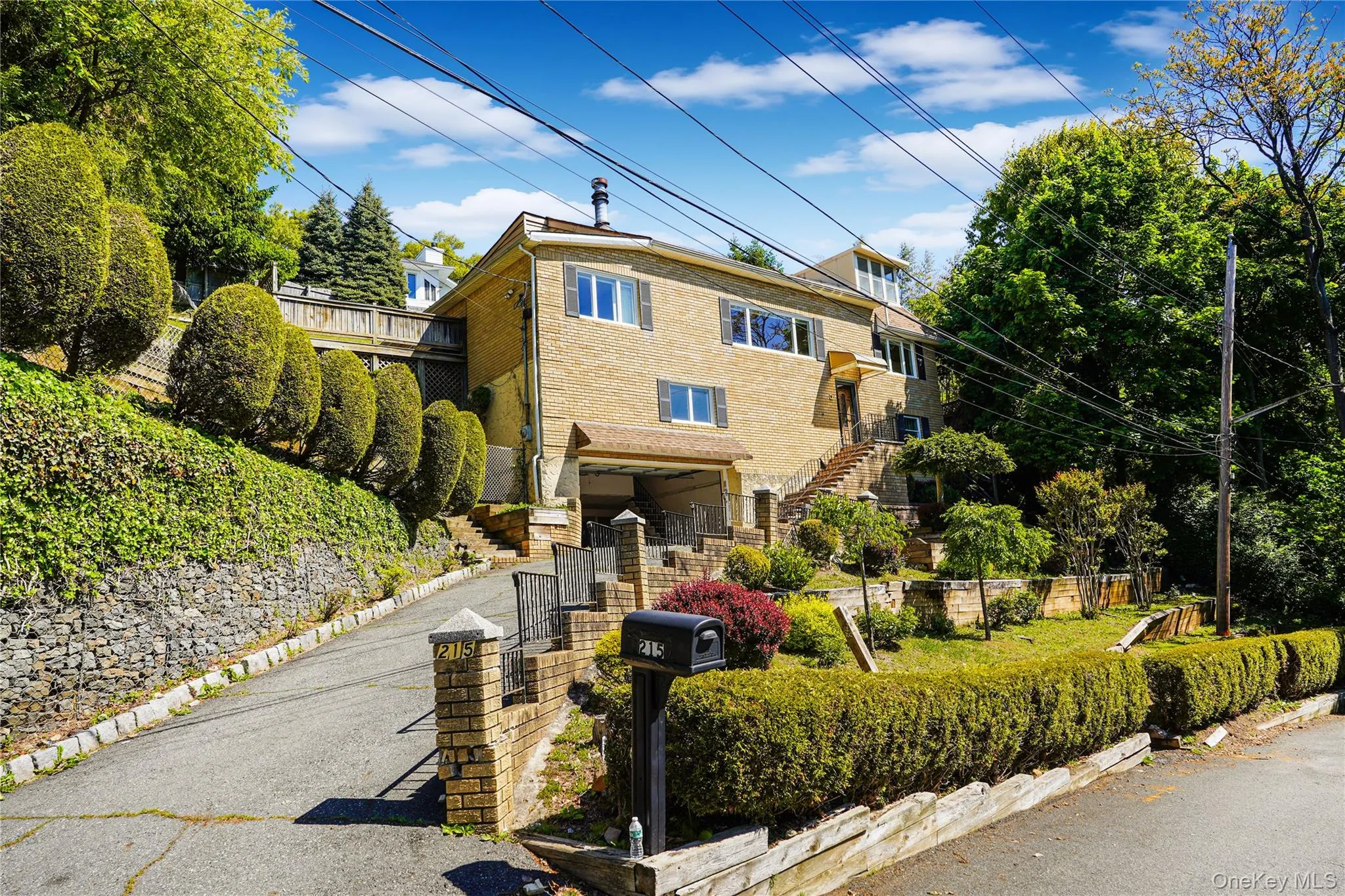Brick exterior residence featuring multiple levels of terraced landscaping Brick exterior residence featuring multiple levels of terraced landscaping
