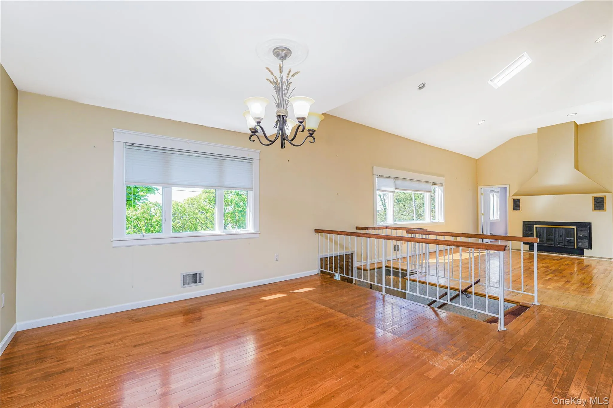Spacious interior featuring wood-finish flooring, vaulted ceilings, and multiple windows Spacious interior featuring wood-finish flooring, vaulted ceilings, and multiple windows
