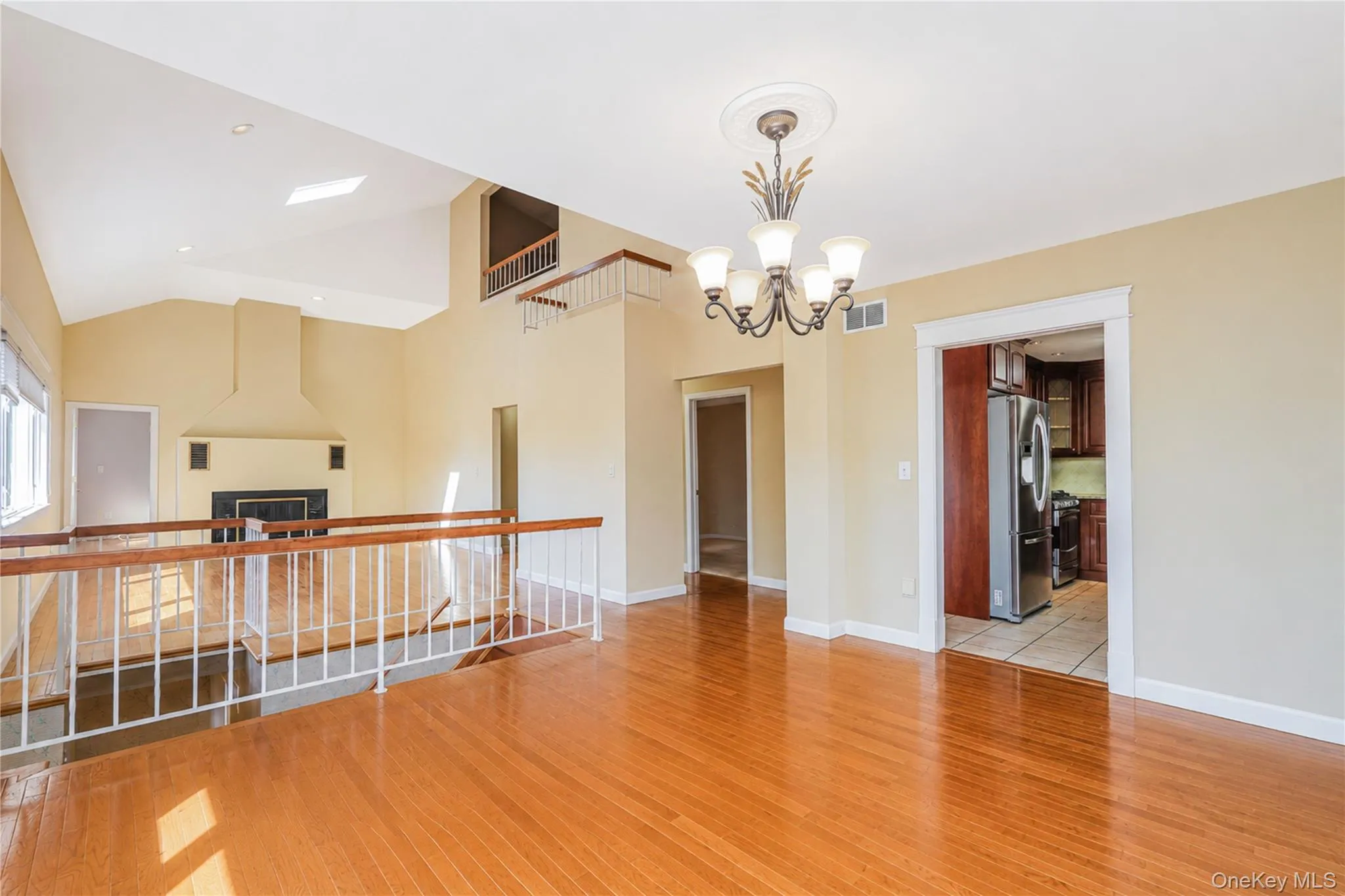 Vaulted ceilings with skylights and recessed lighting, wood-finish flooring, and a decorative chandelier Vaulted ceilings with skylights and recessed lighting, wood-finish flooring, and a decorative chandelier