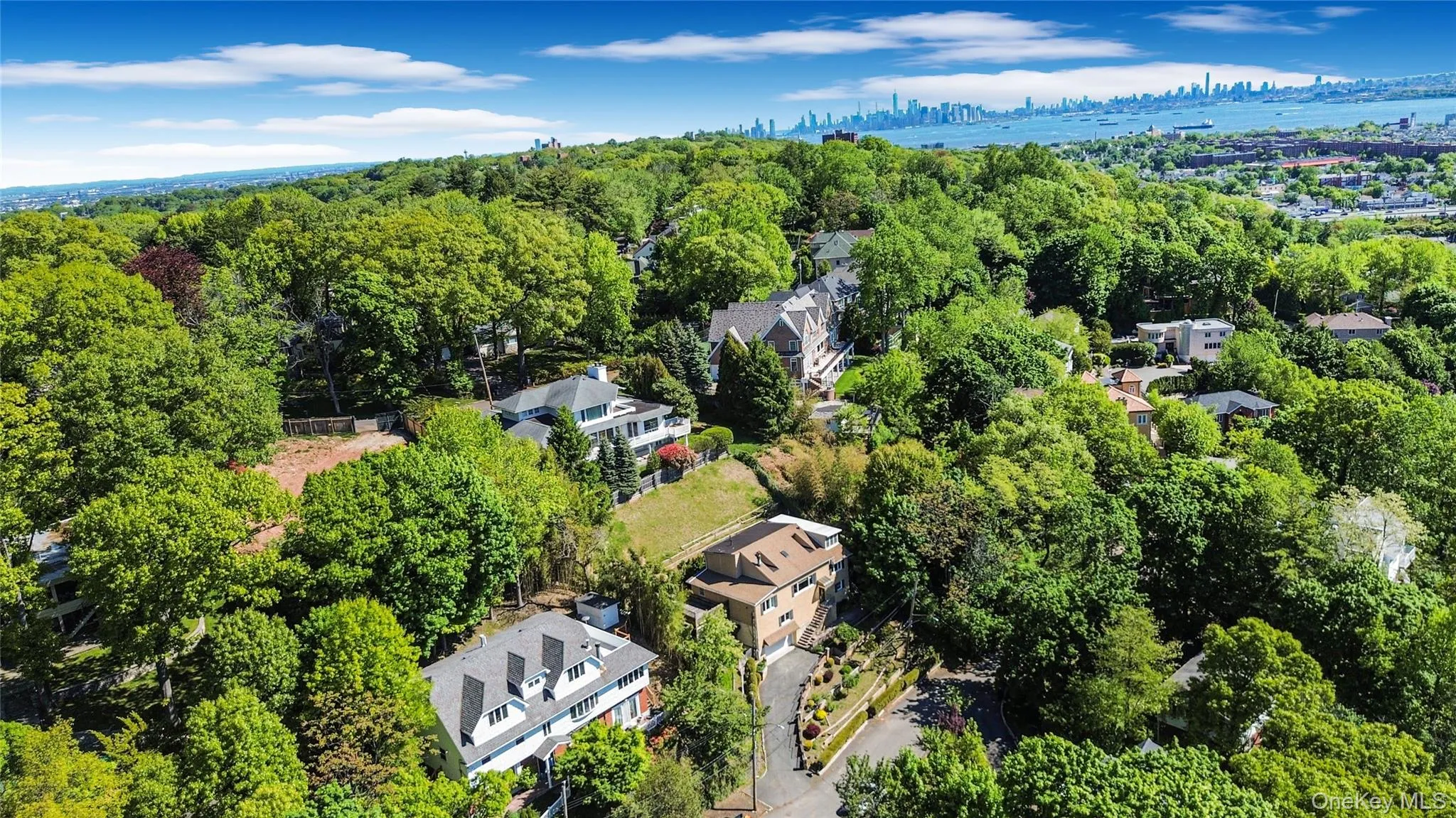 Aerial perspective showcasing multiple residential properties nestled within a verdant, treed landscape Aerial perspective showcasing multiple residential properties nestled within a verdant, treed landscape