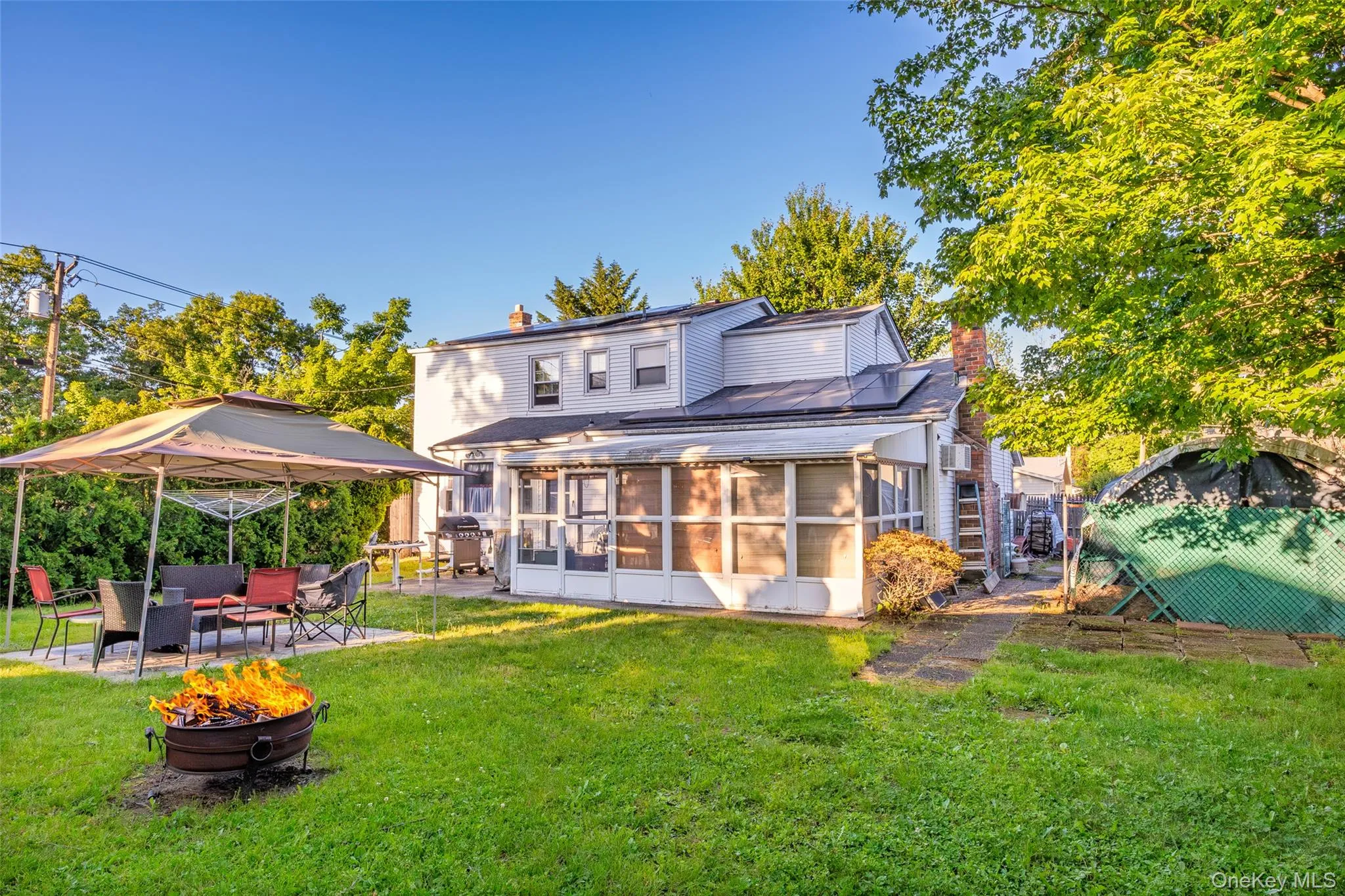 Spacious rear yard with a concrete patio, screen-enclosed porch, and lots of privacy trees Spacious rear yard with a concrete patio, screen-enclosed porch, and lots of privacy trees
