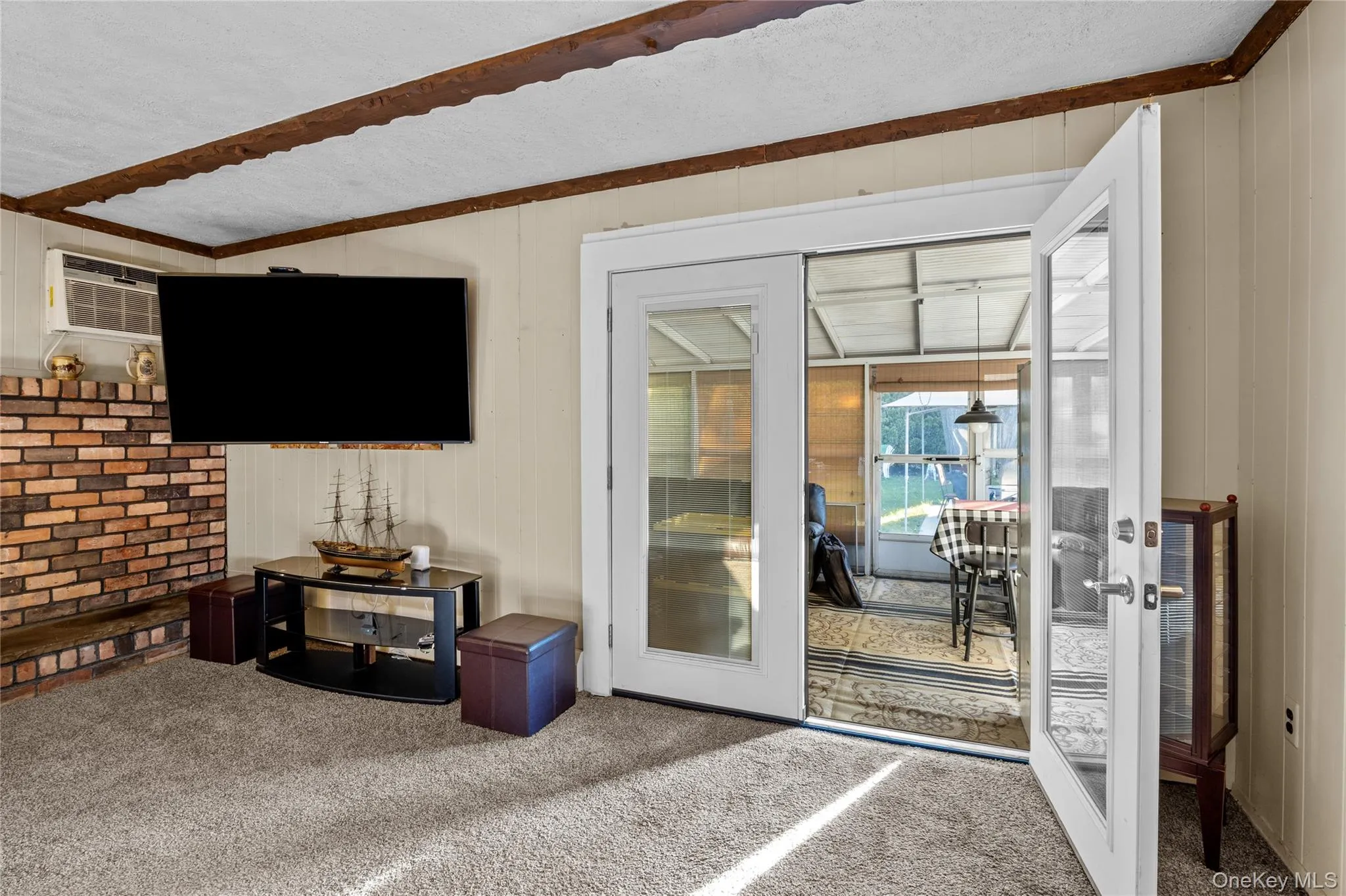 Family Room featuring a wood burning fireplace with access to sun room Family Room featuring a wood burning fireplace with access to sun room