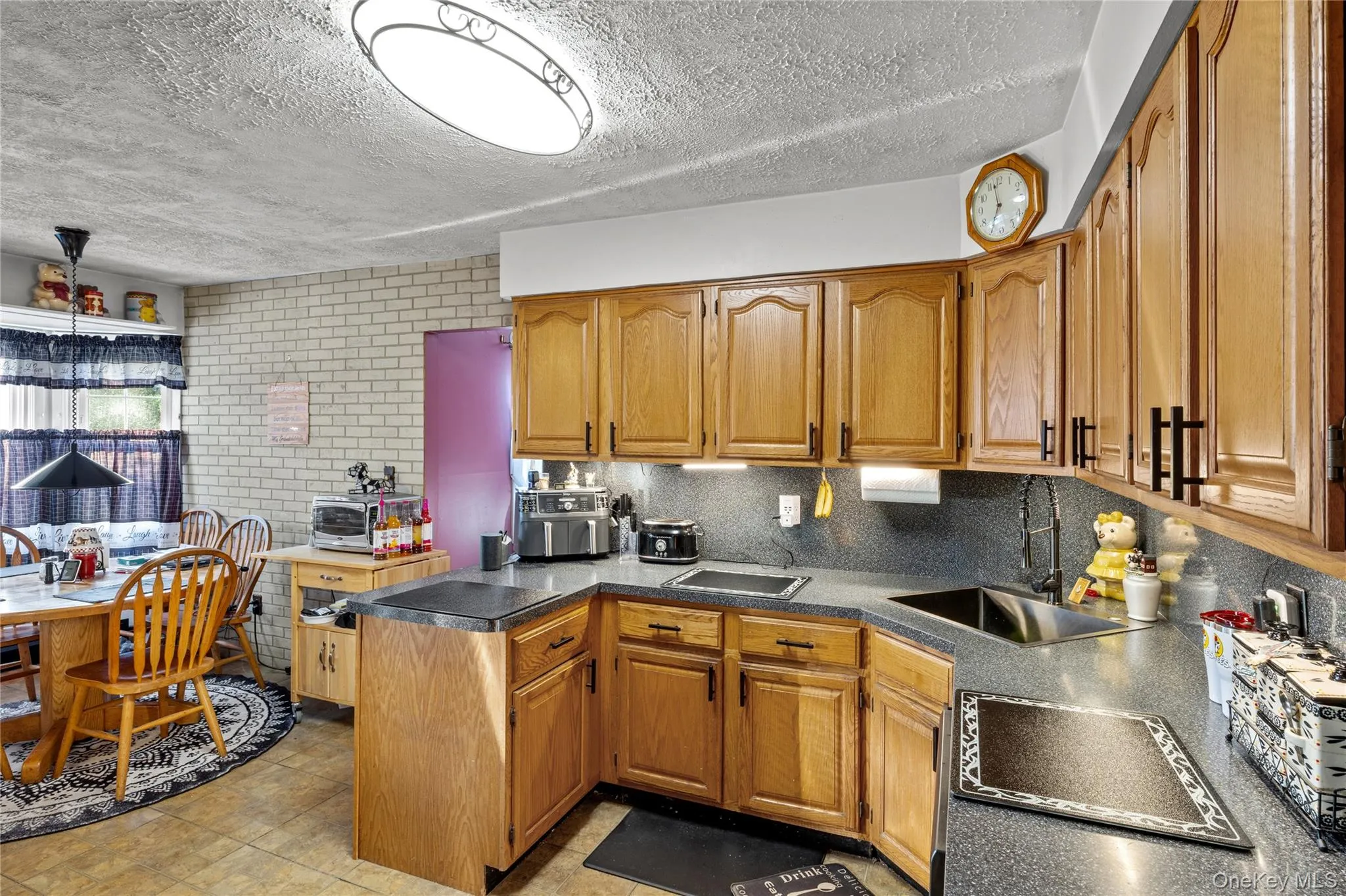 Open Kitchen area featuring wood-finish cabinetry and a stainless steel sink Open Kitchen area featuring wood-finish cabinetry and a stainless steel sink