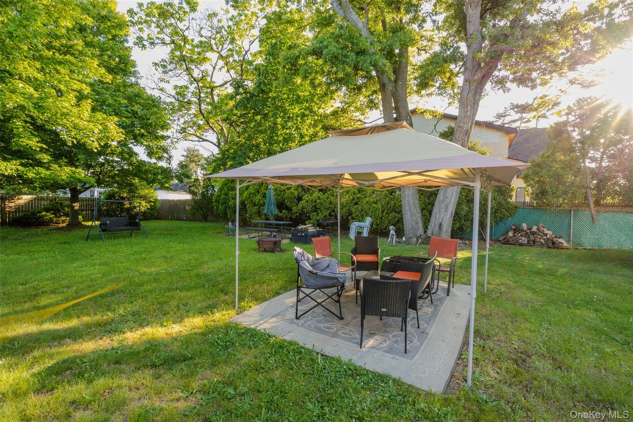 Expansive grassy yard with trees and a dedicated patio area Expansive grassy yard with trees and a dedicated patio area