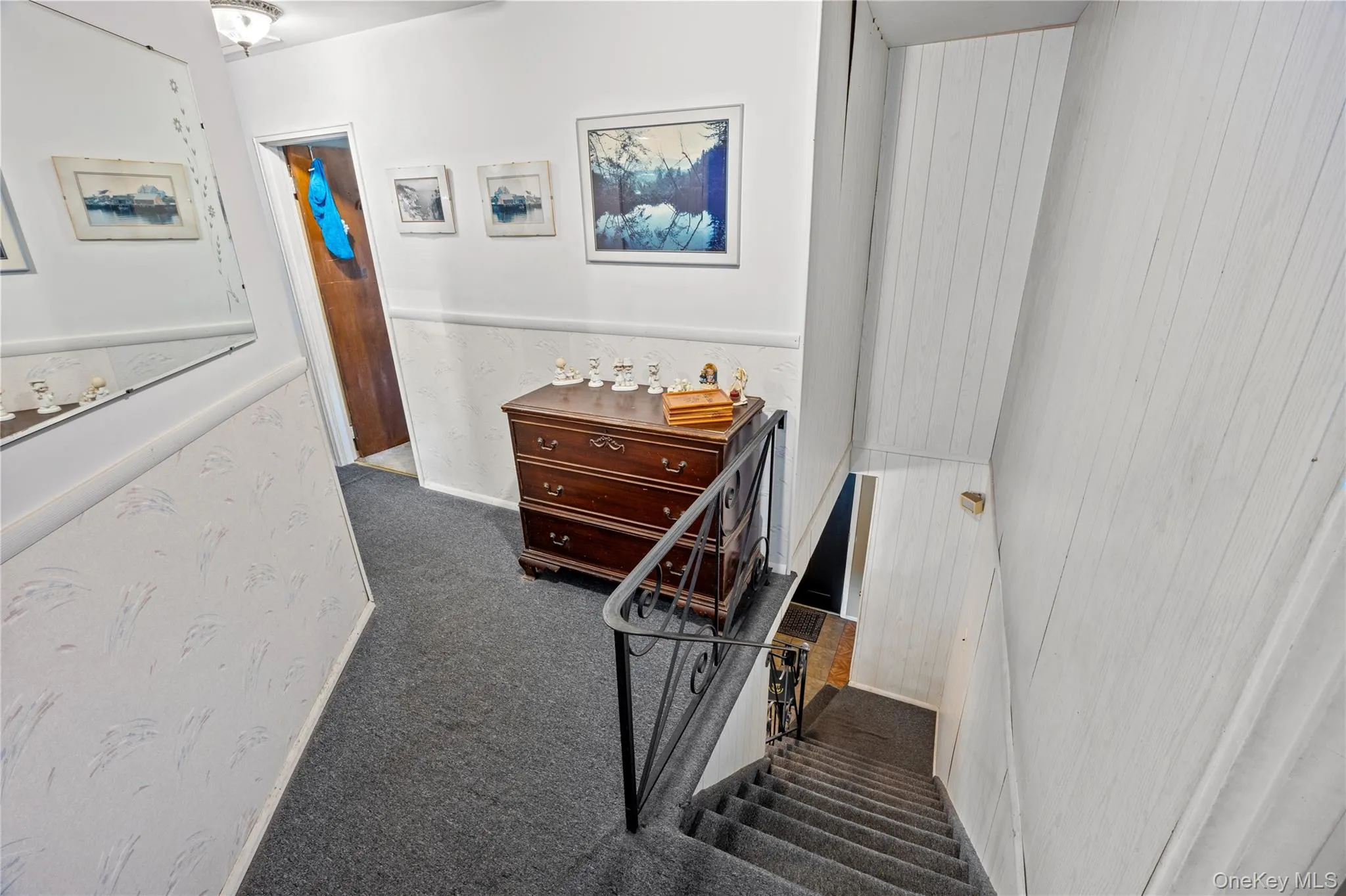 Carpeted staircase with black wrought iron railing, leading to bedrooms hallway Carpeted staircase with black wrought iron railing, leading to bedrooms hallway