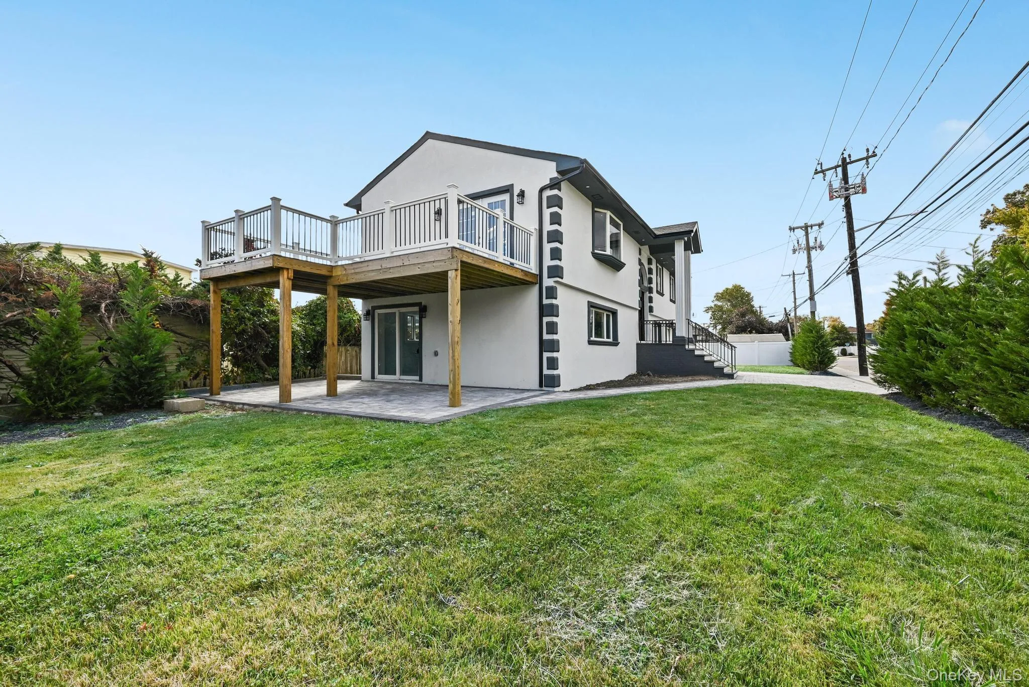 Back of property featuring stucco siding, a patio area, a lawn, and a deck Back of property featuring stucco siding, a patio area, a lawn, and a deck