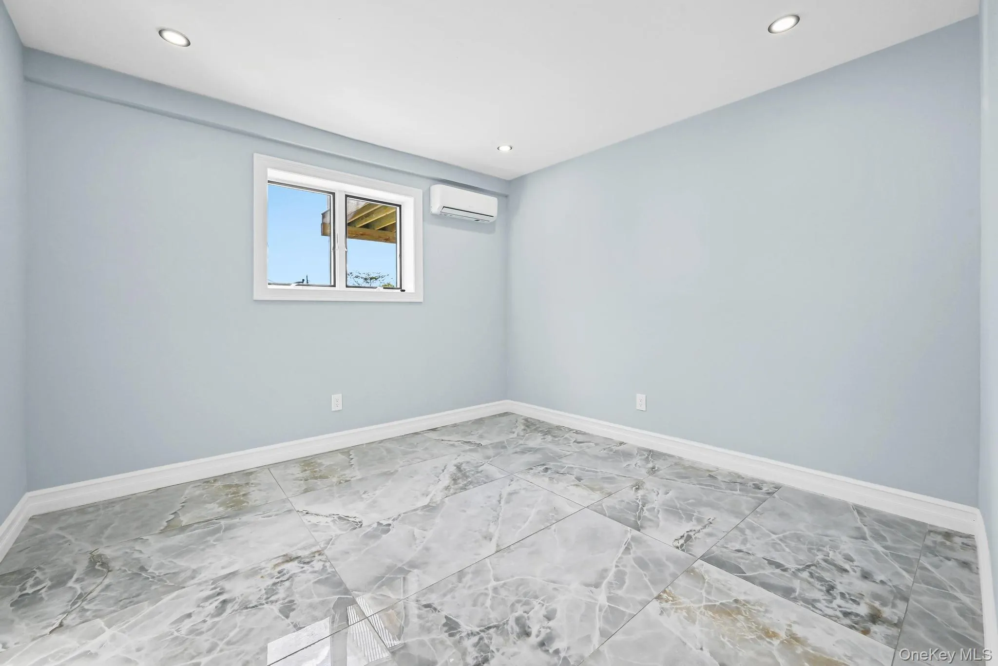 Unfurnished room featuring recessed lighting and an AC wall unit Unfurnished room featuring recessed lighting and an AC wall unit