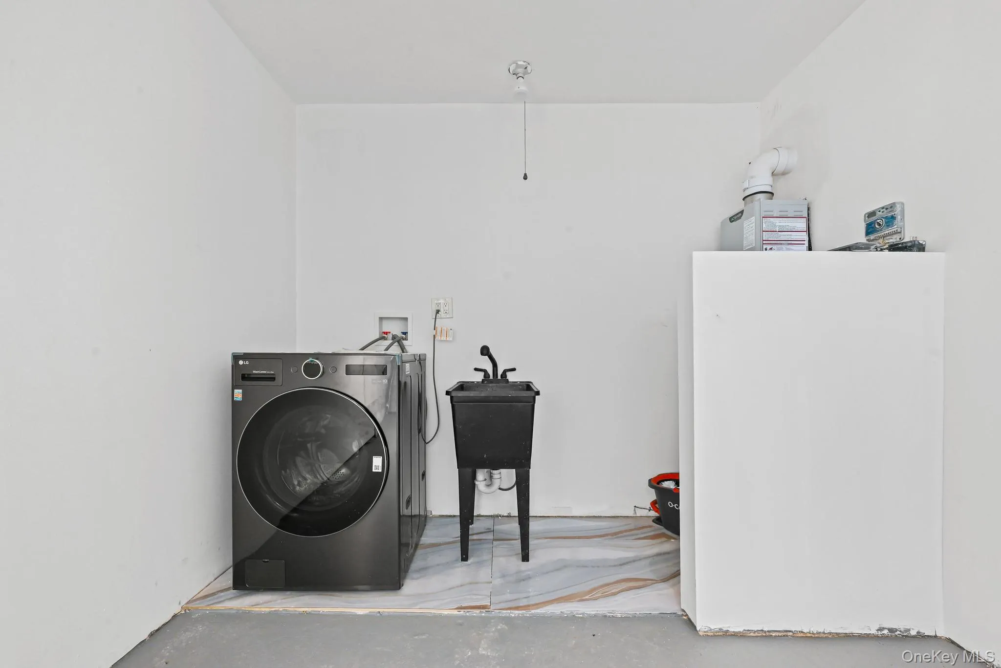 Laundry room featuring washer / dryer and concrete flooring Laundry room featuring washer / dryer and concrete flooring