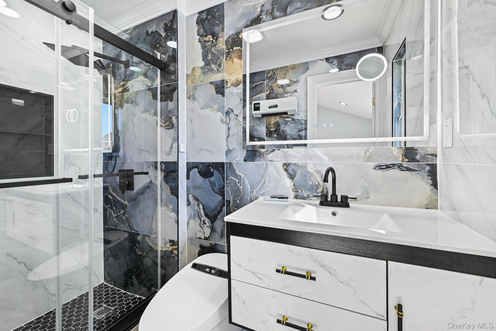 Bathroom with tile walls, a marble finish shower, and vanity Bathroom with tile walls, a marble finish shower, and vanity
