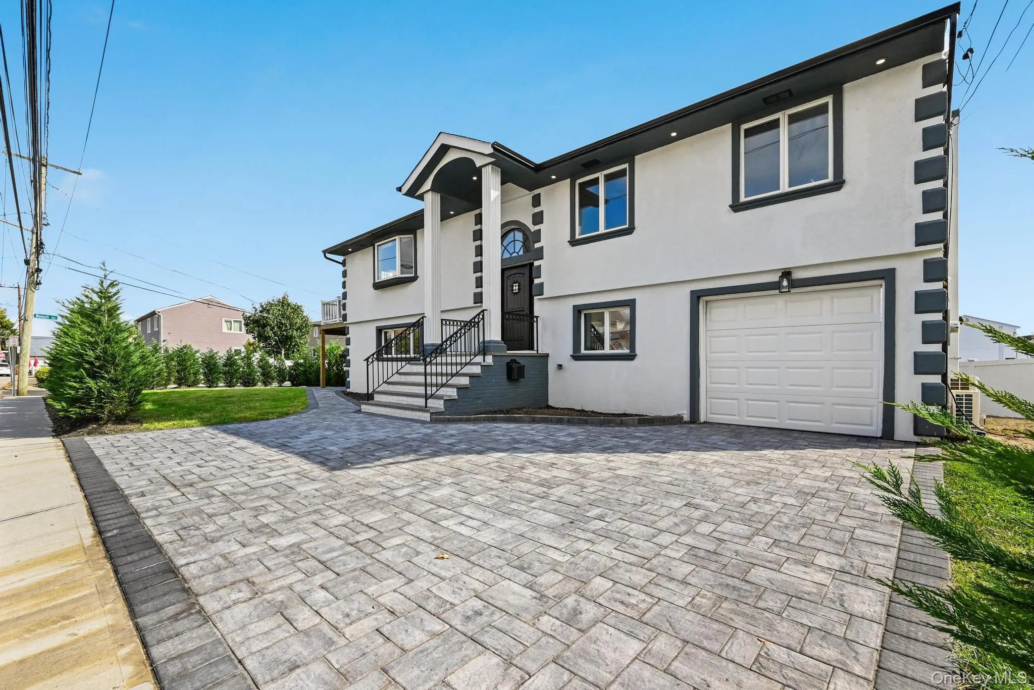 View of front facade featuring stucco siding, a garage, and decorative driveway View of front facade featuring stucco siding, a garage, and decorative driveway