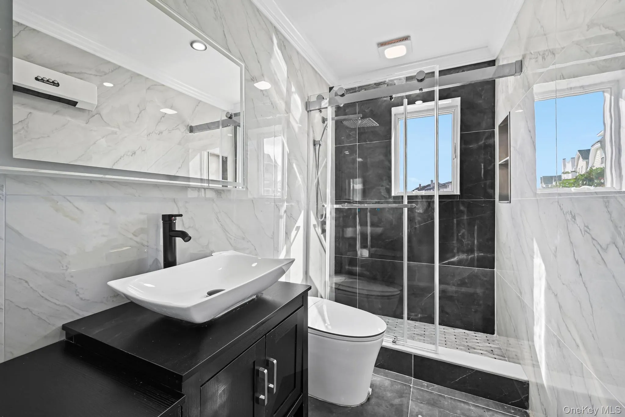 Bathroom with tile walls, vanity, a marble finish shower, and ornamental molding Bathroom with tile walls, vanity, a marble finish shower, and ornamental molding