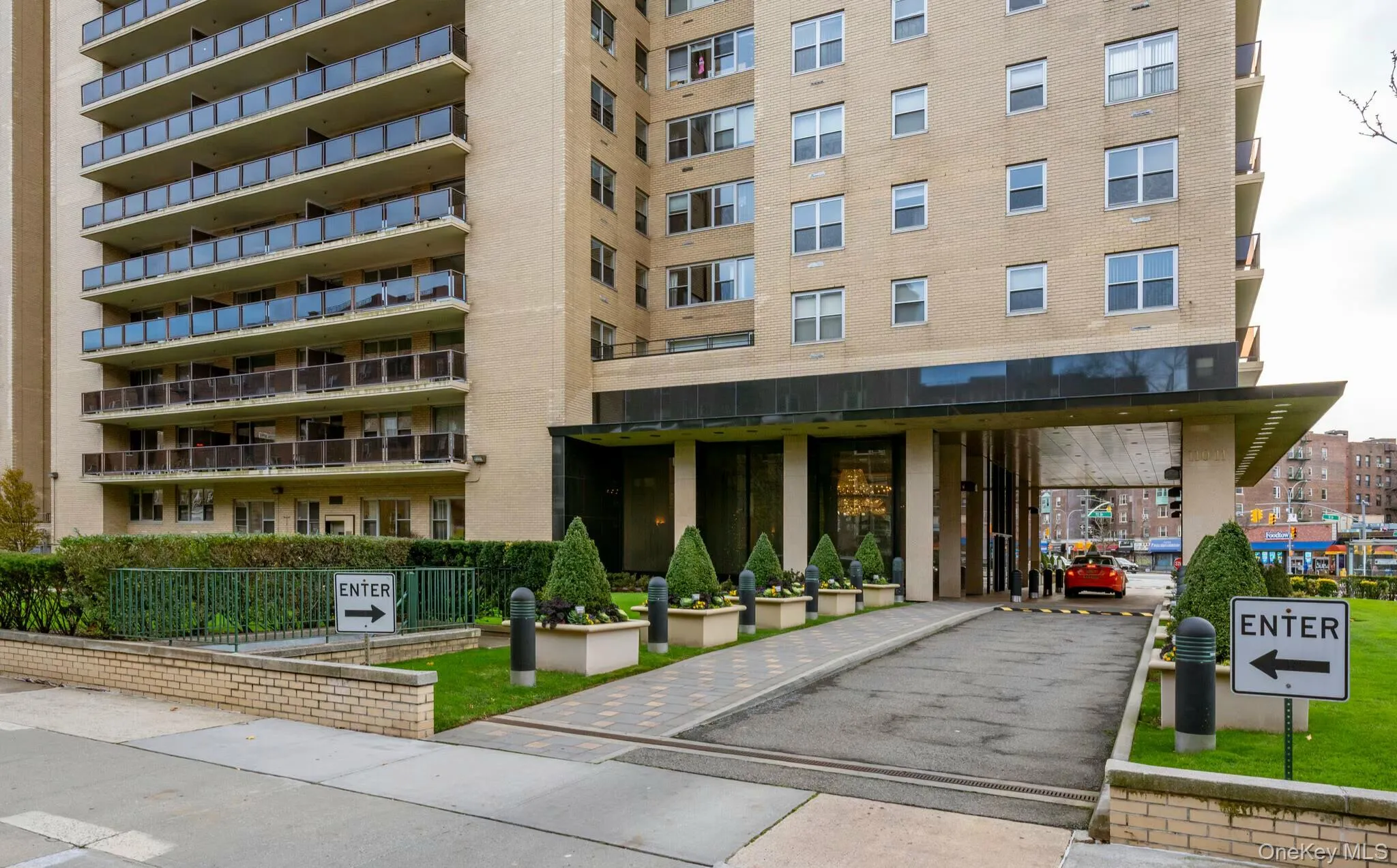 Multi-story building exterior featuring a brick facade and multiple balconies with glass railings Multi-story building exterior featuring a brick facade and multiple balconies with glass railings