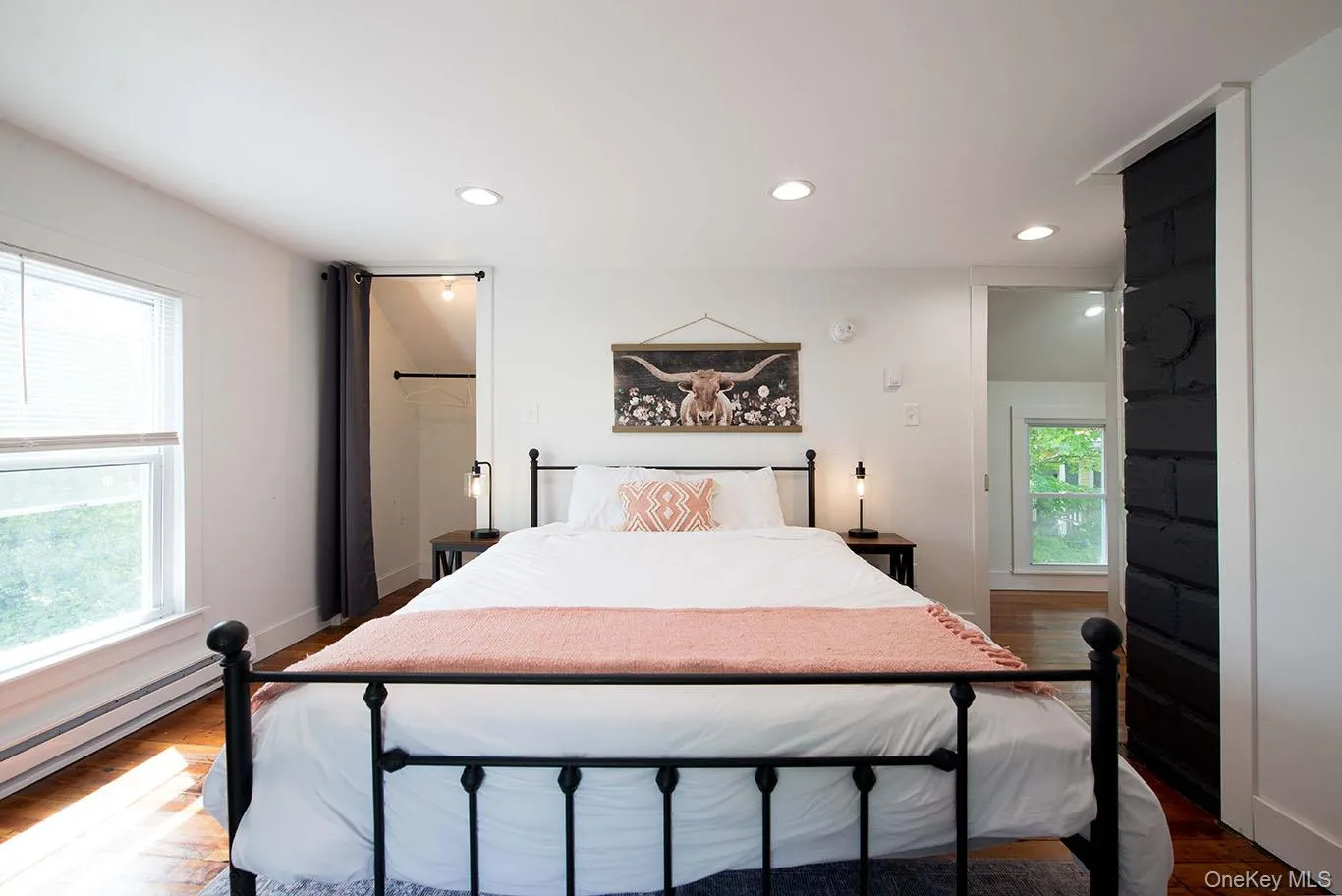 Room featuring recessed lighting, hardwood flooring, and a large window with blinds Room featuring recessed lighting, hardwood flooring, and a large window with blinds