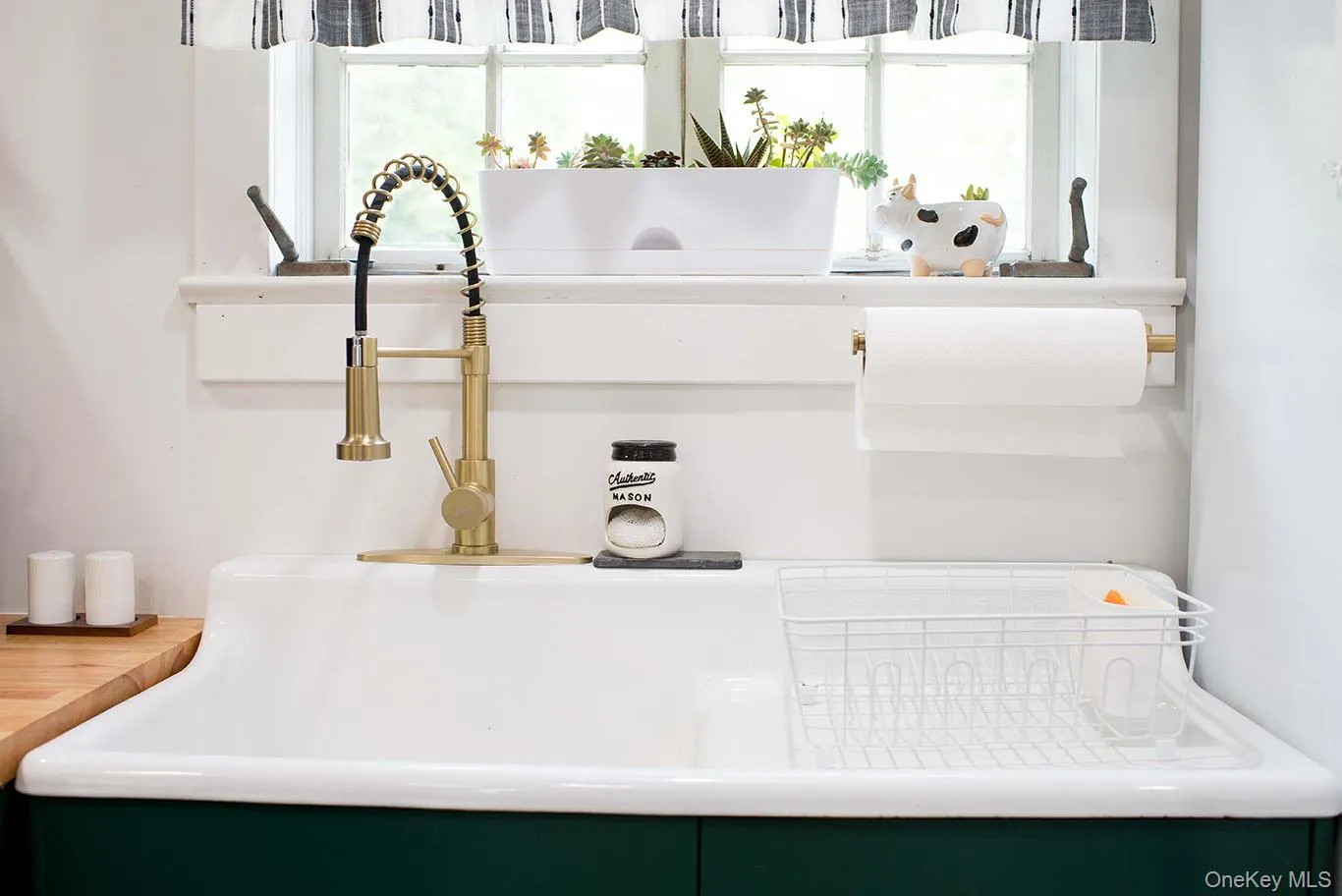 Deep white farmhouse-style sink with a gold-tone pull-down faucet Deep white farmhouse-style sink with a gold-tone pull-down faucet