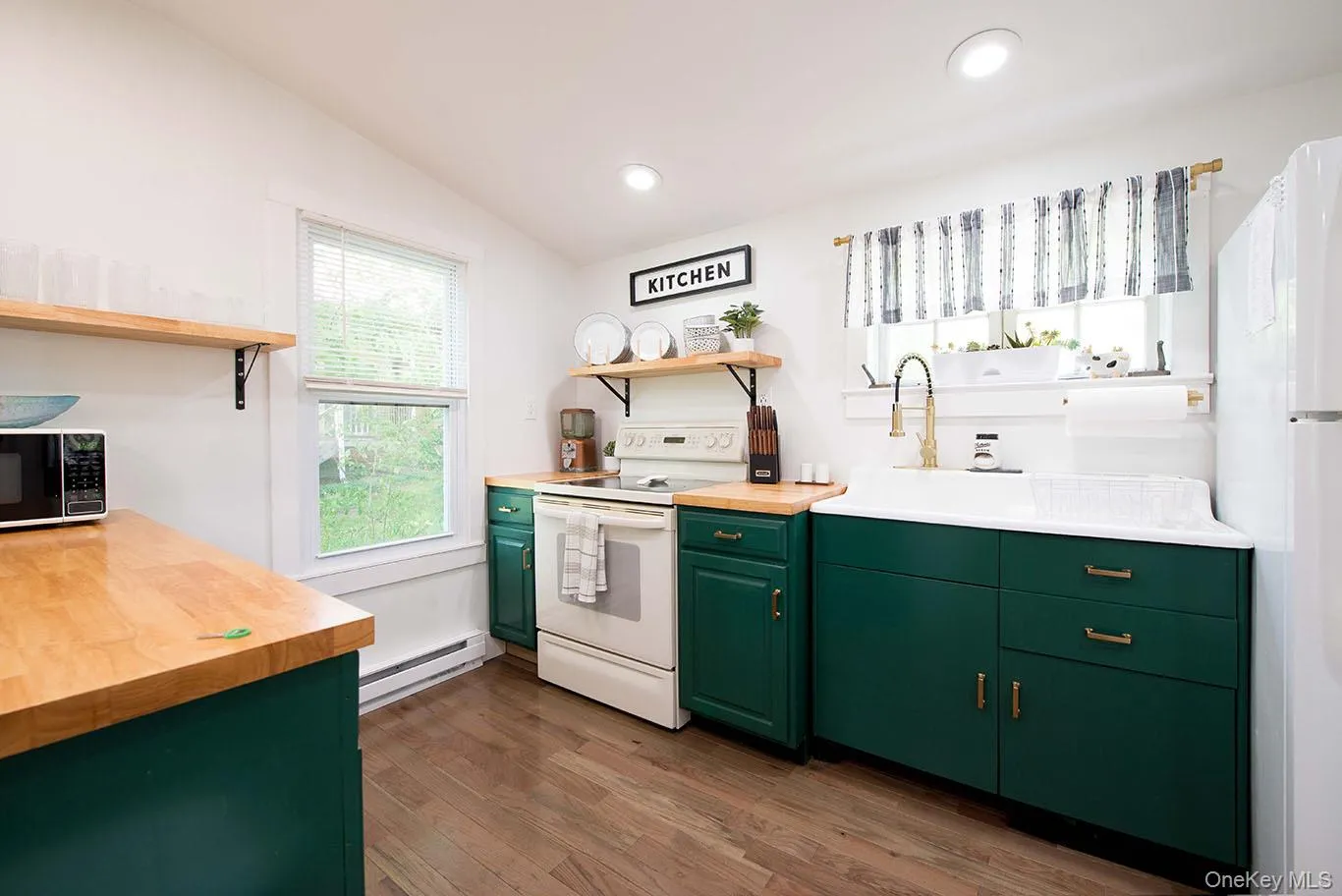 Kitchen featuring wood-finish flooring, recessed lighting, and a white farmhouse sink Kitchen featuring wood-finish flooring, recessed lighting, and a white farmhouse sink