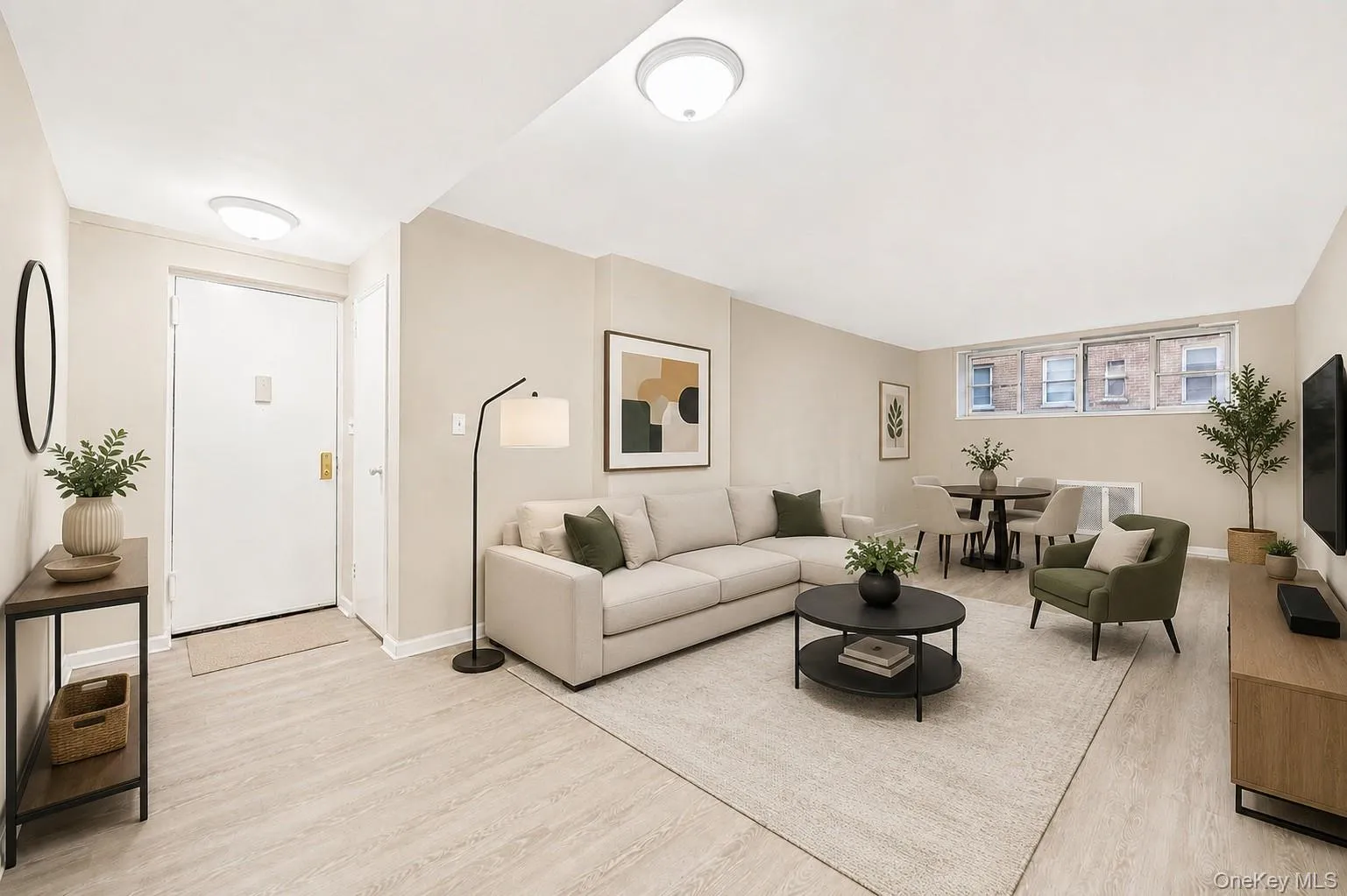 Spacious living area featuring light wood-finish flooring and neutral-toned walls Spacious living area featuring light wood-finish flooring and neutral-toned walls