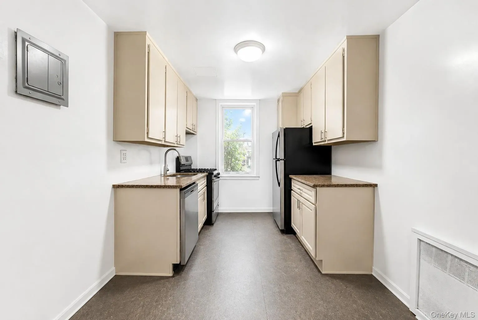 Galley kitchen featuring light-toned cabinetry, granite-style countertops, and wood-finish flooring Galley kitchen featuring light-toned cabinetry, granite-style countertops, and wood-finish flooring