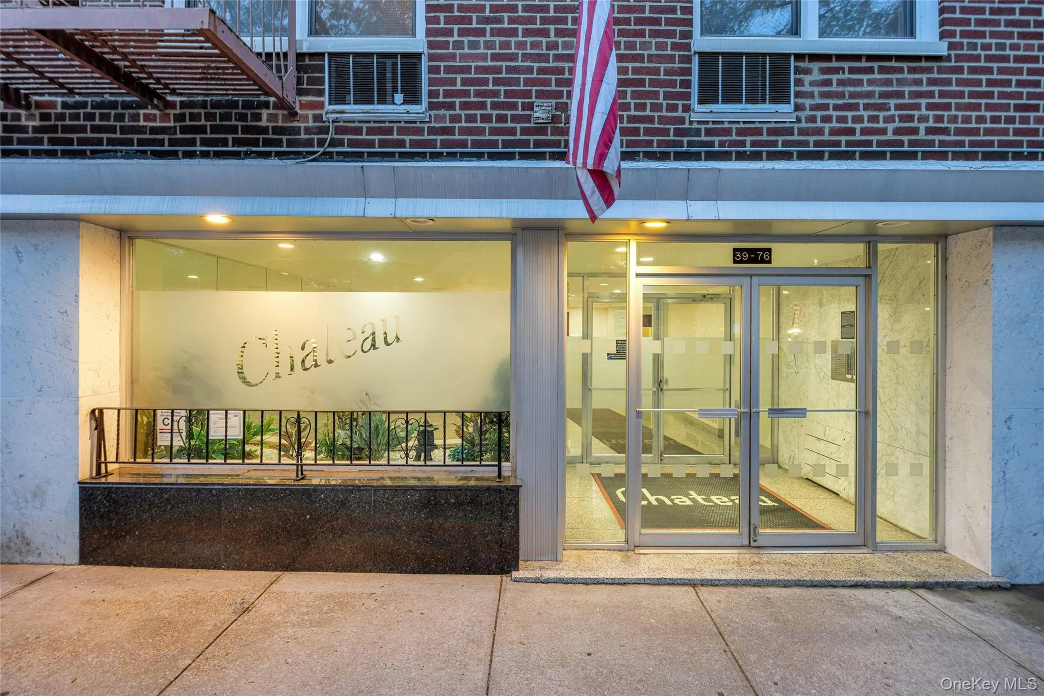 Building entrance featuring frosted glass paneling, aluminum-framed double doors, and an integrated display window with interior lighting Building entrance featuring frosted glass paneling, aluminum-framed double doors, and an integrated display window with interior lighting