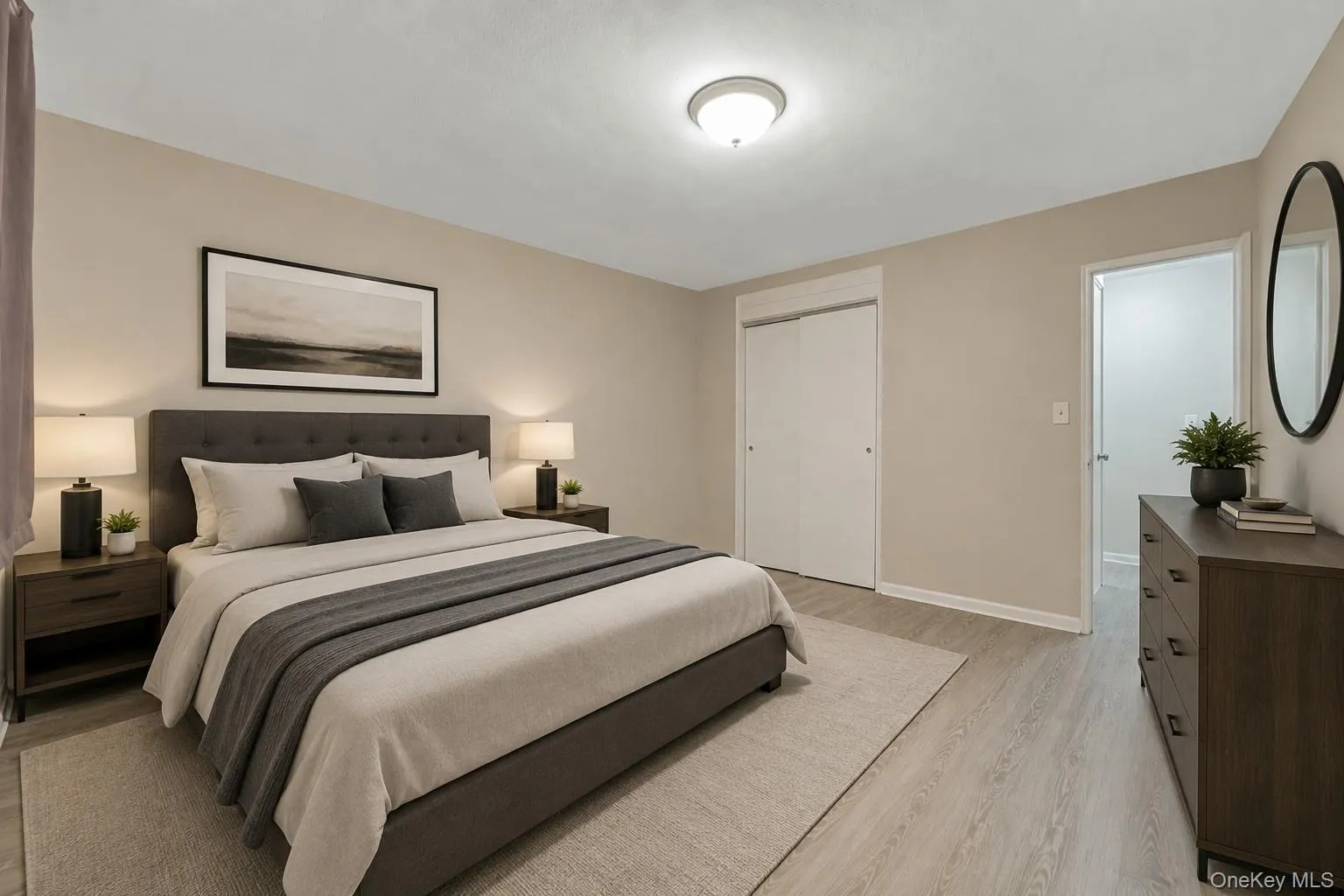 Neutral-toned room featuring light wood-finish flooring and a ceiling-mounted light fixture Neutral-toned room featuring light wood-finish flooring and a ceiling-mounted light fixture