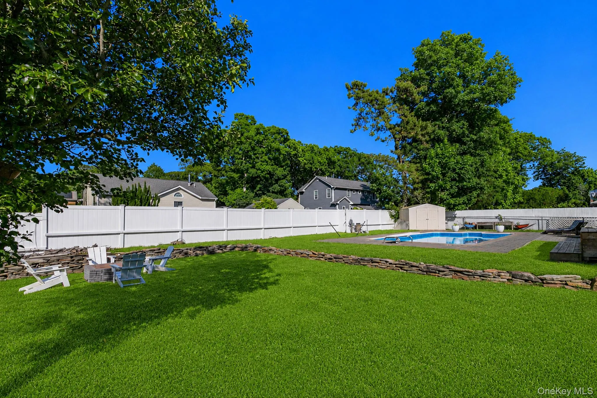 The Large Fully PVC Fenced Backyard Has Beautiful Stone/Rock Walls, Expansive Lawns/Beautiful Grasses With Ample Room For Entertaining, And A Firepit Area. The Large Fully PVC Fenced Backyard Has Beautiful Stone/Rock Walls, Expansive Lawns/Beautiful Grasses With Ample Room For Entertaining, And A Firepit Area.