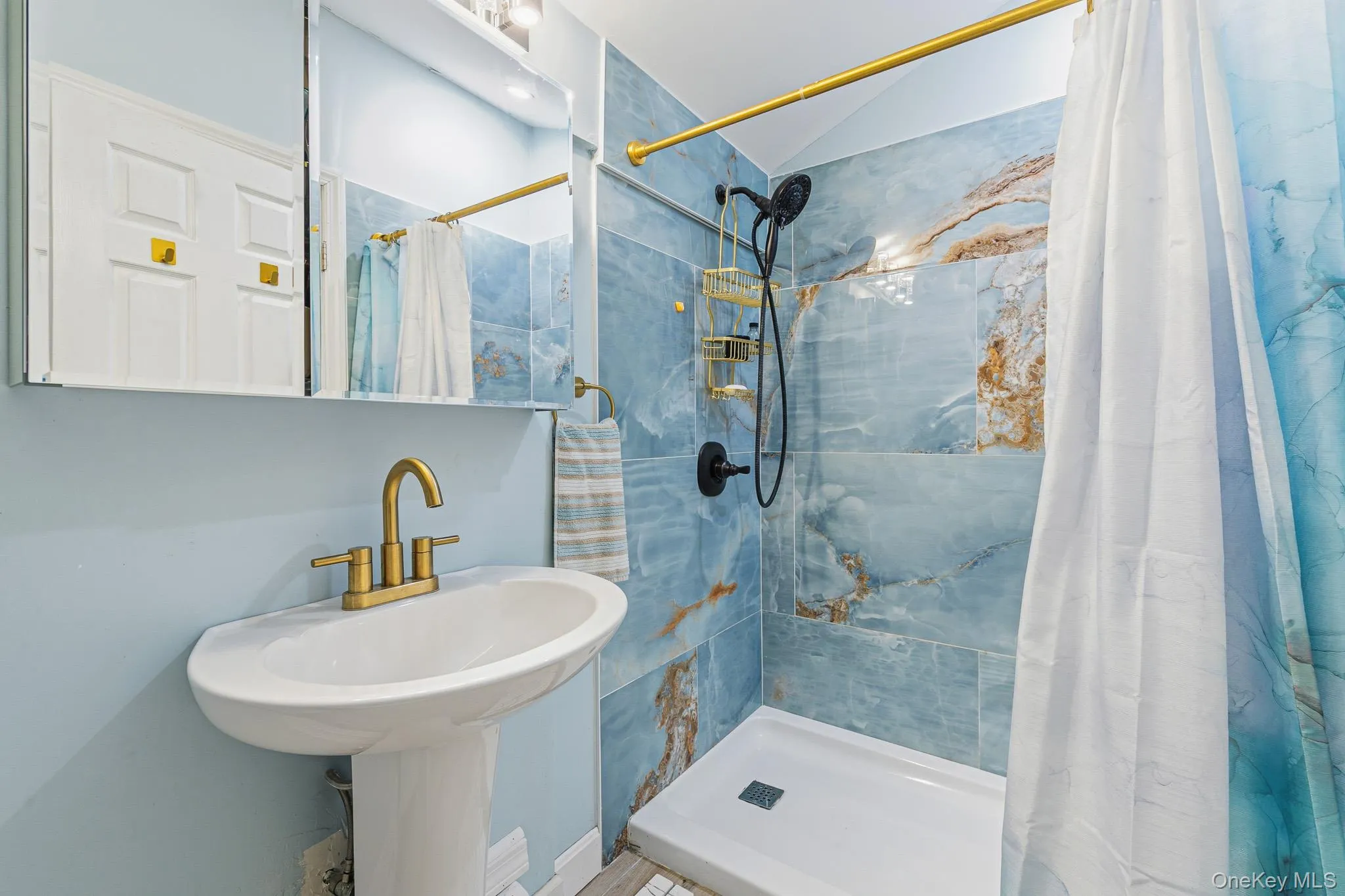 The Beautifully Renovated Primary Bathroom Offers An Oversized Custom Shower With Stunning 24" x 48" Porcelain Tiled Walls, Pedestal Sink, Plank Tiled Floors & All Upgraded Fixtures. The Beautifully Renovated Primary Bathroom Offers An Oversized Custom Shower With Stunning 24" x 48" Porcelain Tiled Walls, Pedestal Sink, Plank Tiled Floors & All Upgraded Fixtures.