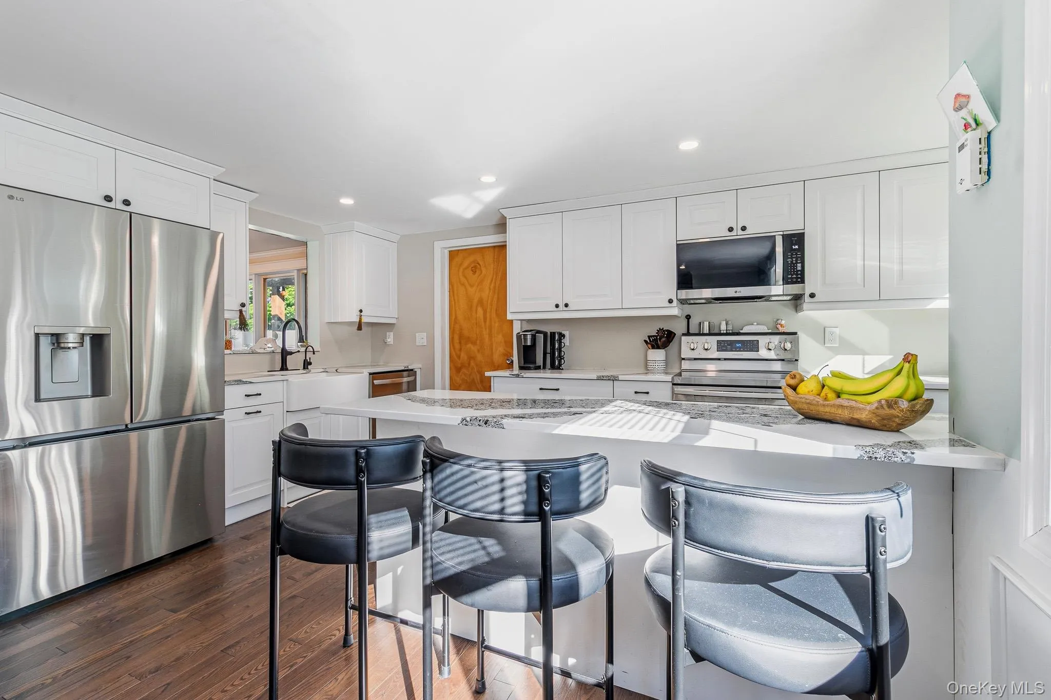 The Stunning Two Year Old Custom Kitchen Offers Walls Of White Shaker Style Cabinetry With Large Pot Drawers & Ample Storage, Accent Quartz Countertops With A Farm Sink & Large Barstool/Counter & Serving Space, Hardwood Floors, Recessed Lighting, Beautiful Crown Moldings, All Stainless Steel Appliances (Including A Samsung Ceramic Top Stove, LG Built In Microwave Oven, LG French Door Refrigerator With Bottom Freezer, Water & Ice Maker, And LG Dishwasher), And An Opening/Pass Through Into The Dining Room. The Stunning Two Year Old Custom Kitchen Offers Walls Of White Shaker Style Cabinetry With Large Pot Drawers & Ample Storage, Accent Quartz Countertops With A Farm Sink & Large Barstool/Counter & Serving Space, Hardwood Floors, Recessed Lighting, Beautiful Crown Moldings, All Stainless Steel Appliances (Including A Samsung Ceramic Top Stove, LG Built In Microwave Oven, LG French Door Refrigerator With Bottom Freezer, Water & Ice Maker, And LG Dishwasher), And An Opening/Pass Through Into The Dining Room.