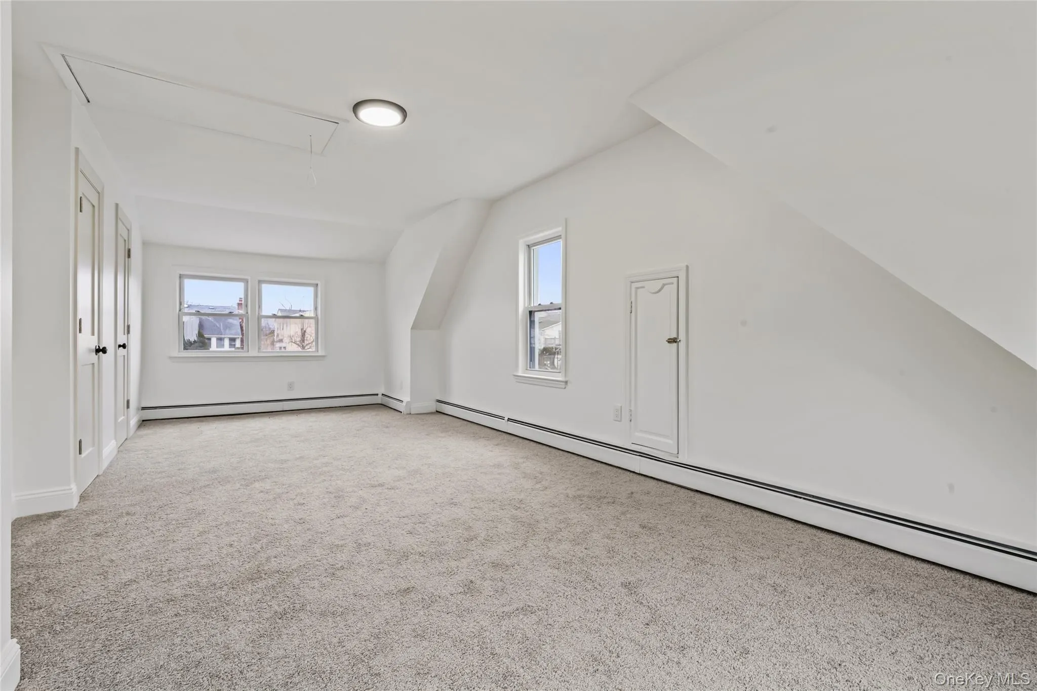 Bonus room with baseboard heating, attic access, light carpet, and lofted ceiling Bonus room with baseboard heating, attic access, light carpet, and lofted ceiling
