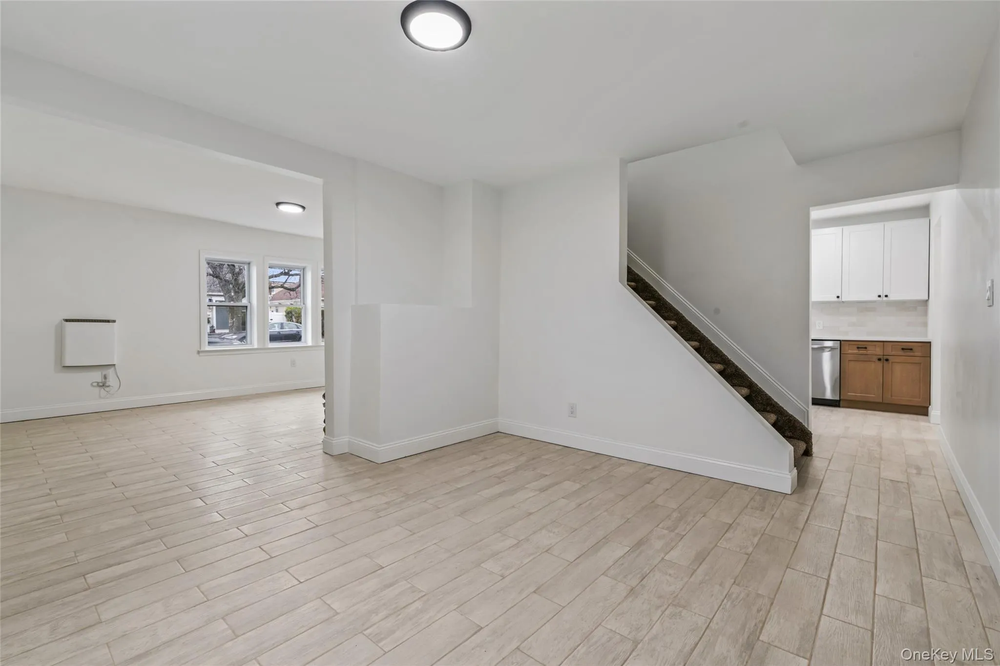Unfurnished living room with stairs and wood tiled floors Unfurnished living room with stairs and wood tiled floors