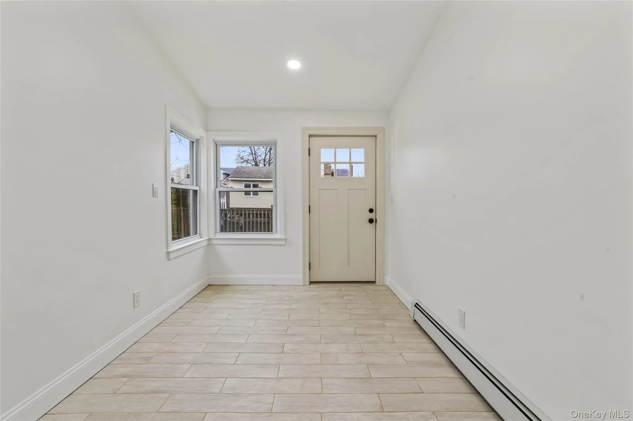 Entrance foyer featuring baseboard heating, wood tiled floors, and recessed lighting Entrance foyer featuring baseboard heating, wood tiled floors, and recessed lighting