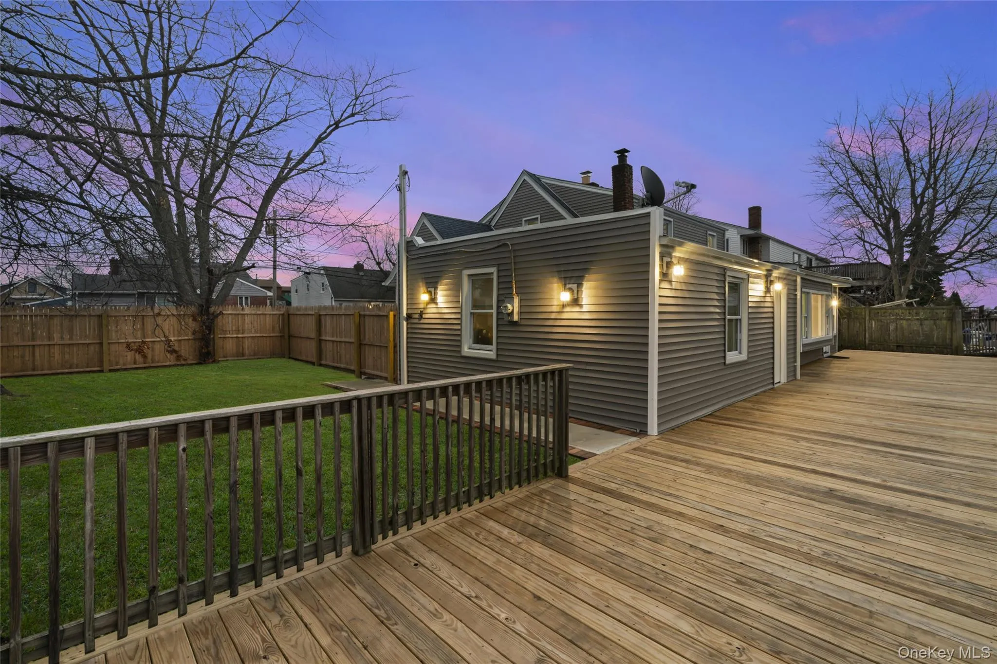 Deck at dusk featuring a fenced backyard Deck at dusk featuring a fenced backyard