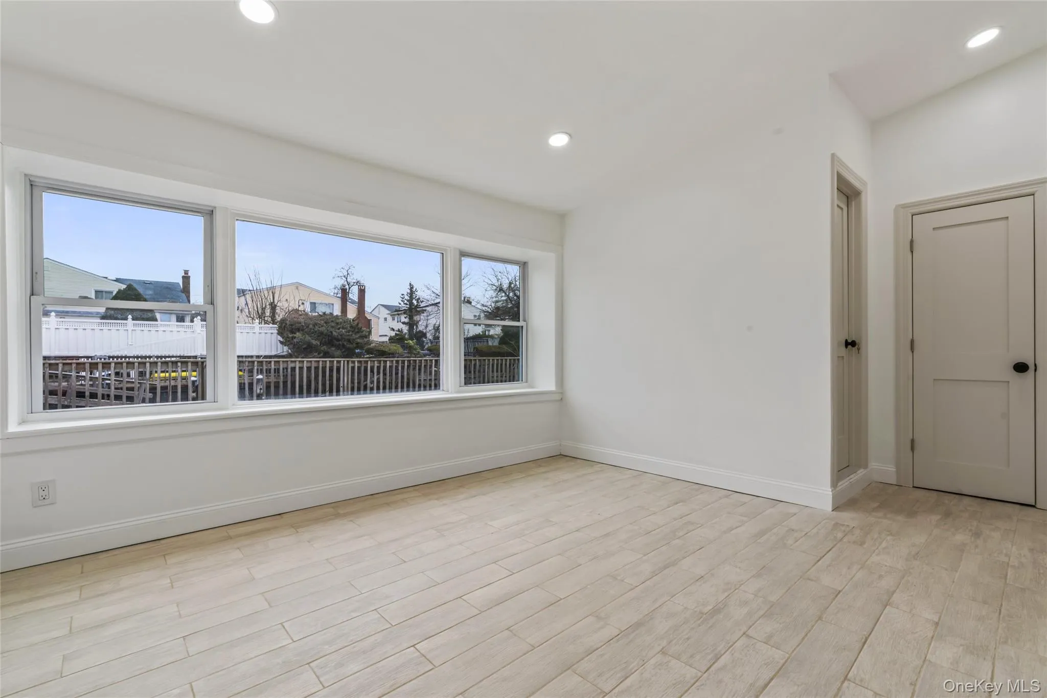 Unfurnished room with light wood finished floors and recessed lighting Unfurnished room with light wood finished floors and recessed lighting