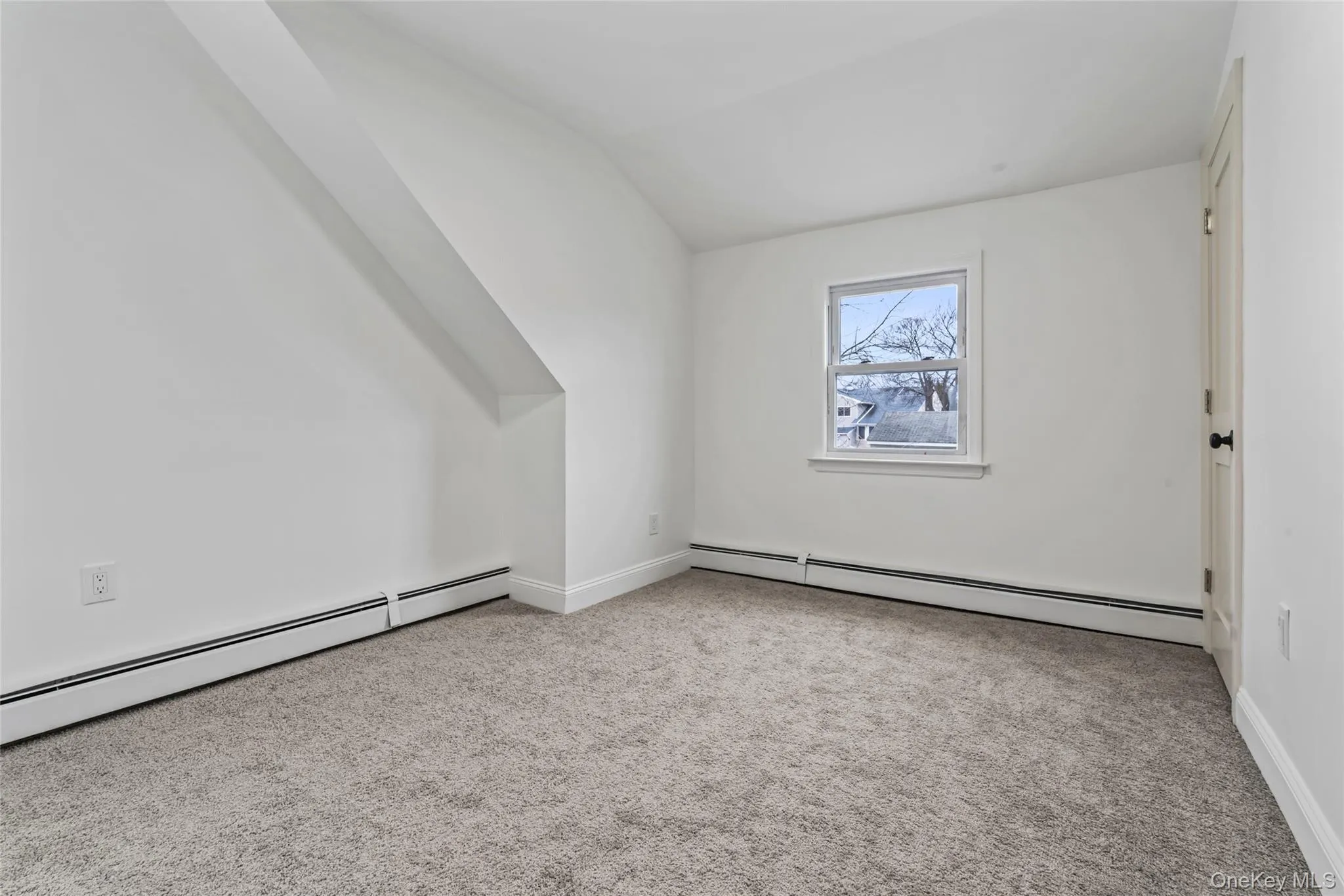 Additional living space featuring light carpet, baseboard heating, and lofted ceiling Additional living space featuring light carpet, baseboard heating, and lofted ceiling