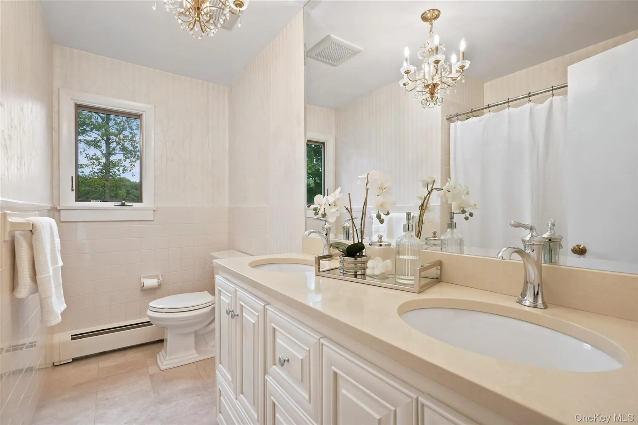 Renovated bath with double vanity and frameless shower doors Renovated bath with double vanity and frameless shower doors